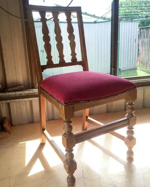 A Wooden Chair With a Red Cushion in Front of a Window — Paulie's Upholstery in Edmonton, QLD