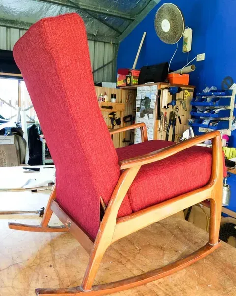 A Red Rocking Chair in a Room With a Blue Wall — Paulie's Upholstery in Edmonton, QLD