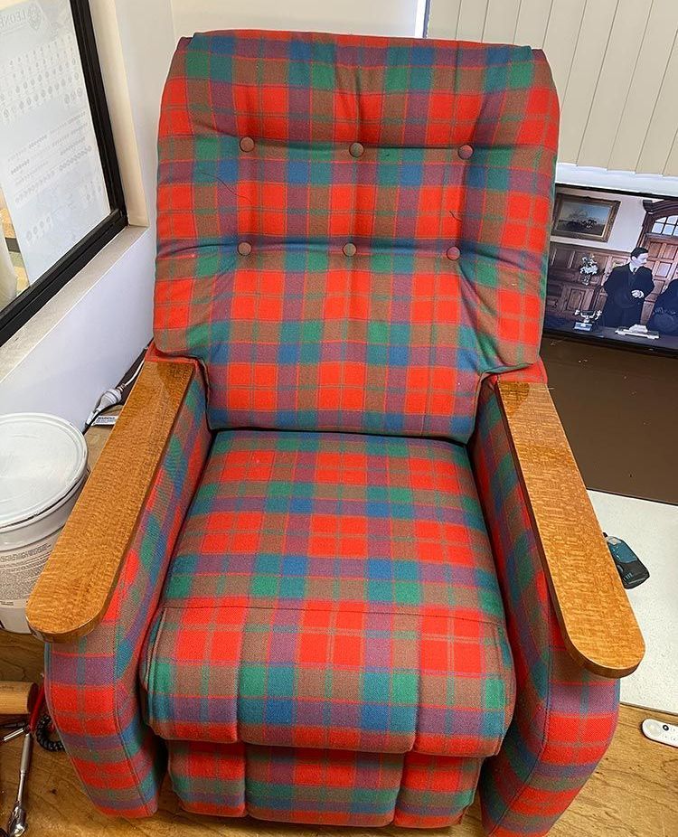 A Red and Green Plaid Recliner is on a Wooden Floor in a Room — Paulie's Upholstery in Edmonton, QLD