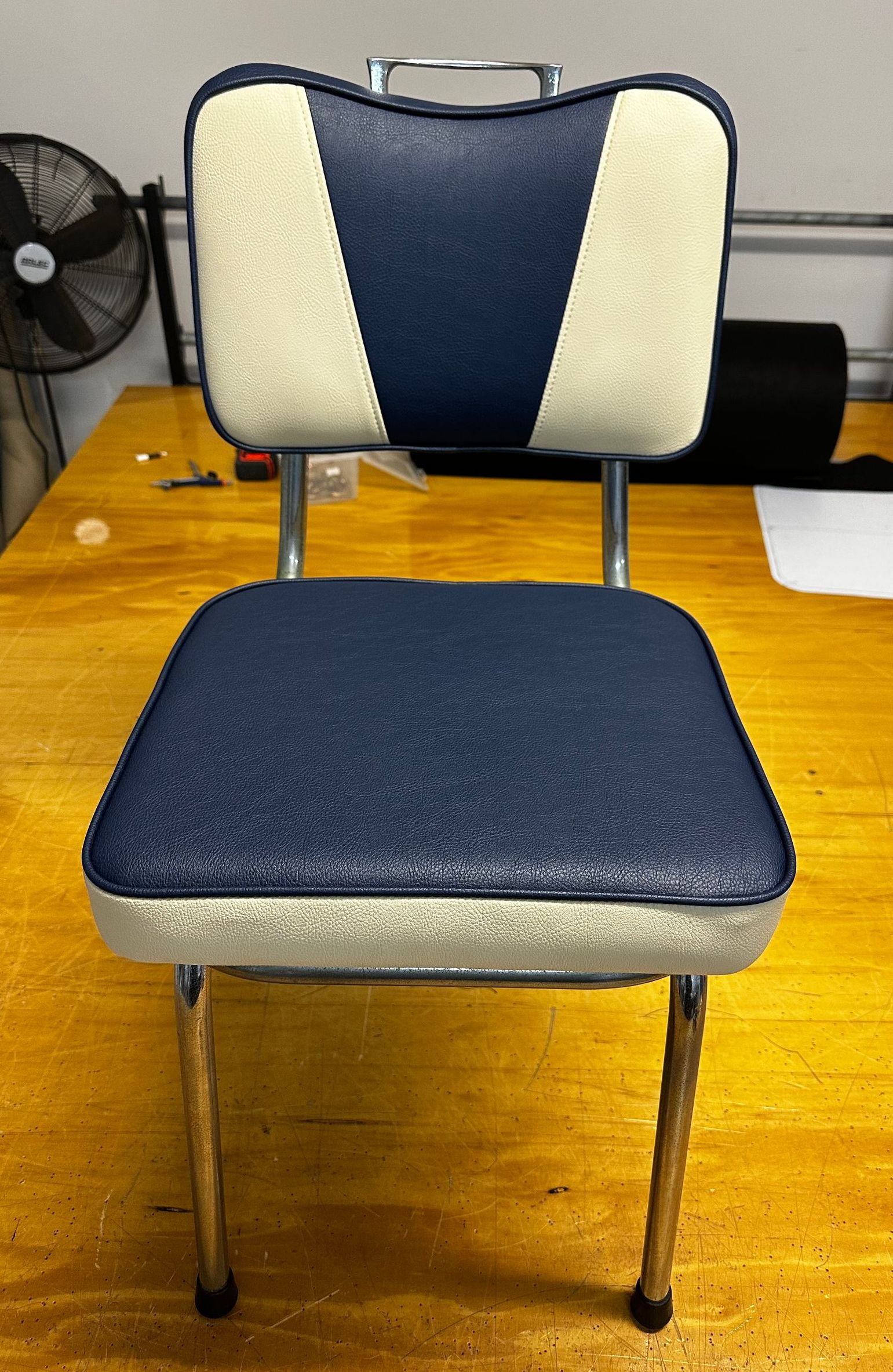 A Blue And White Chair Is On A Wooden Floor — Paulie's Upholstery in Edmonton, QLD