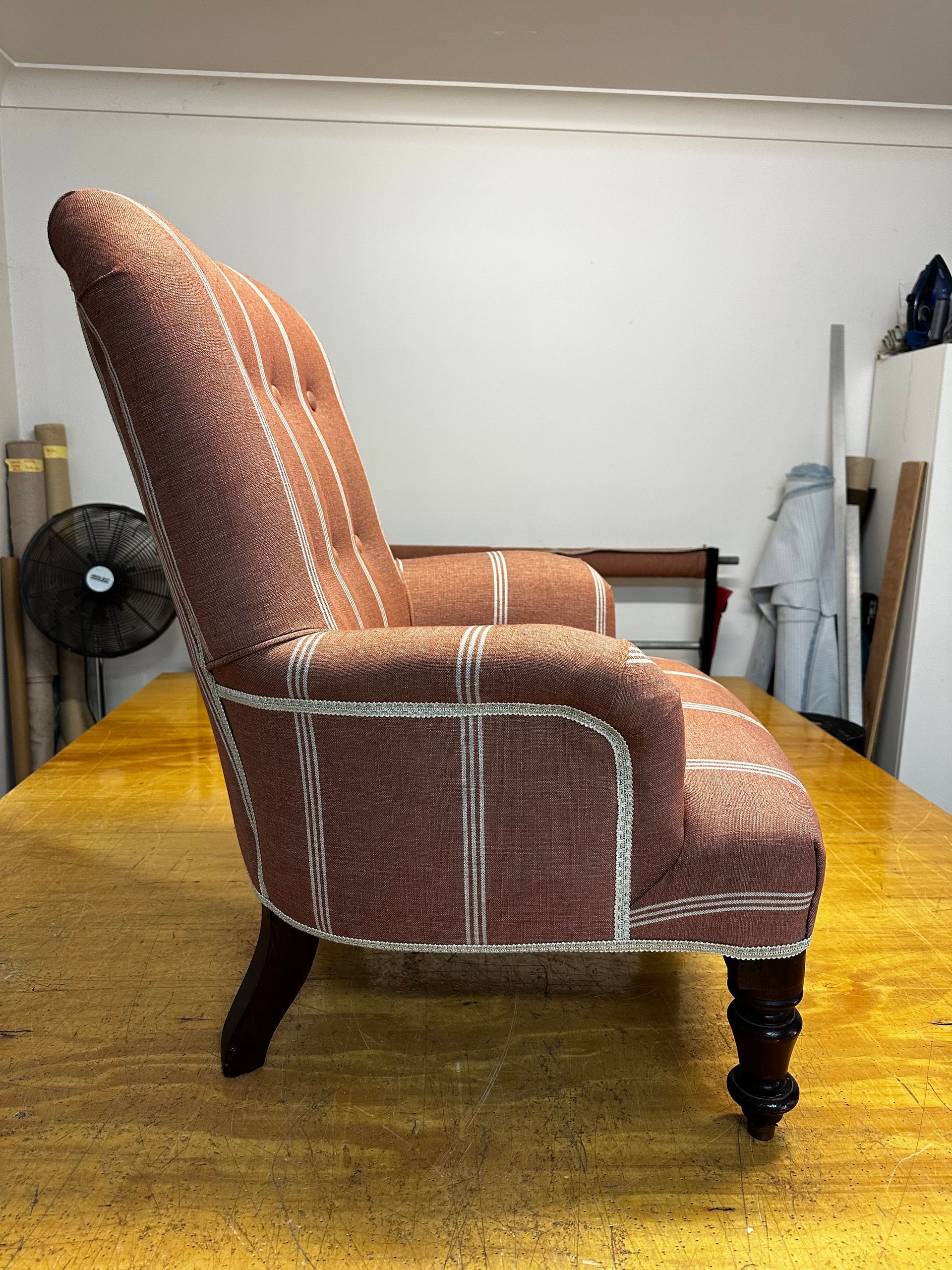 A Red And White Couch Chair On A Wooden Table — Paulie's Upholstery in Edmonton, QLD