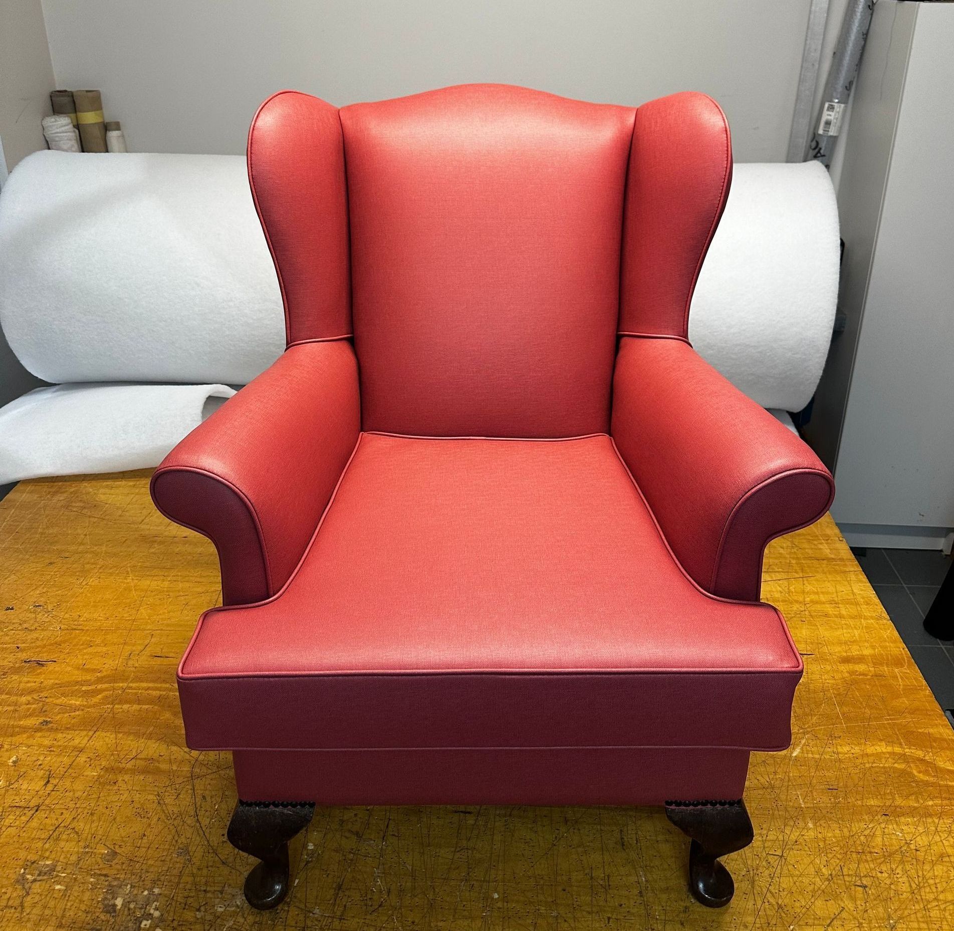 A Red Chair is on Top of a Wooden Table — Paulie's Upholstery in Edmonton, QLD