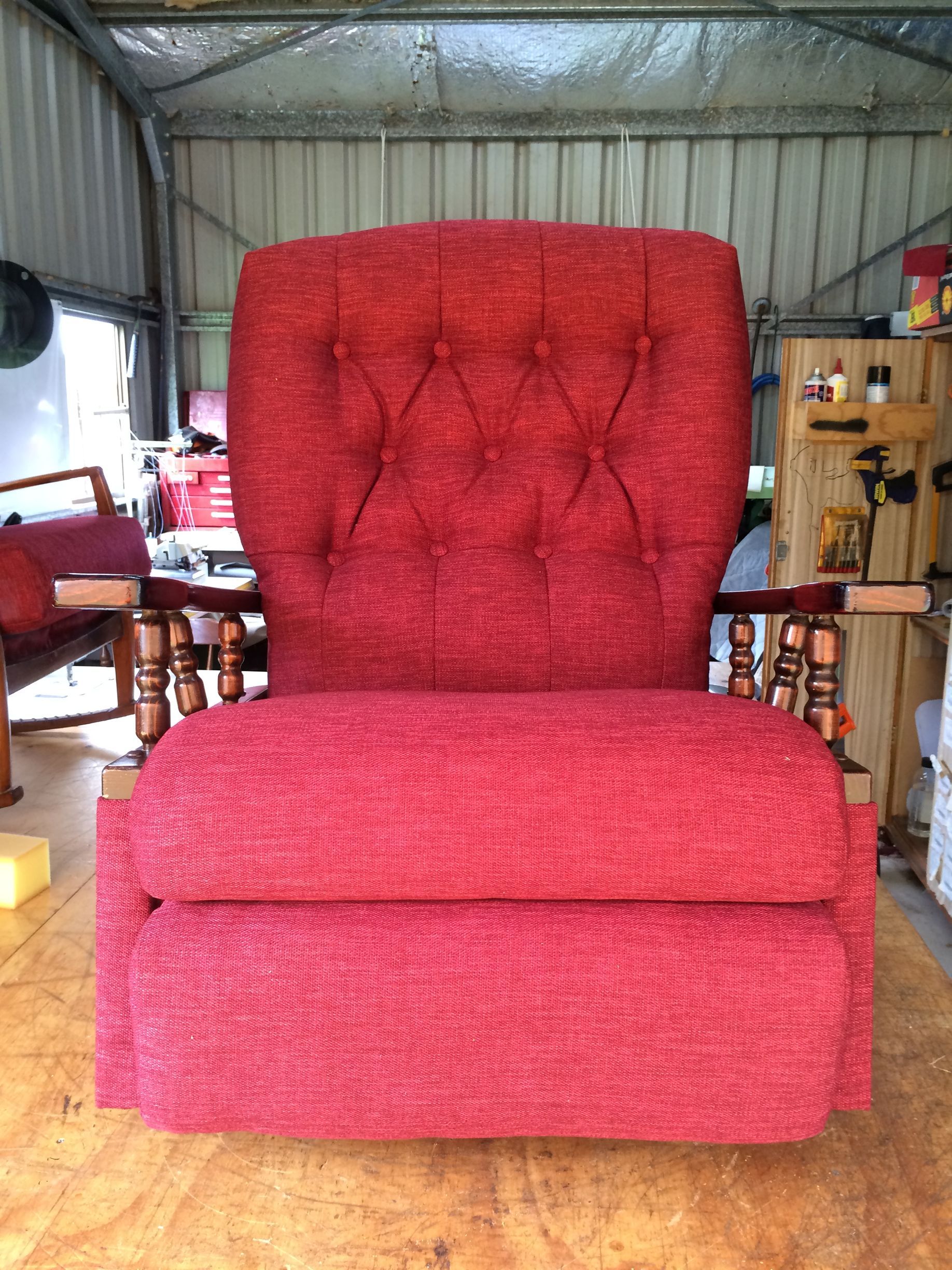 A Red Chair is on a Wooden Table in a Room — Paulie's Upholstery in Edmonton, QLD