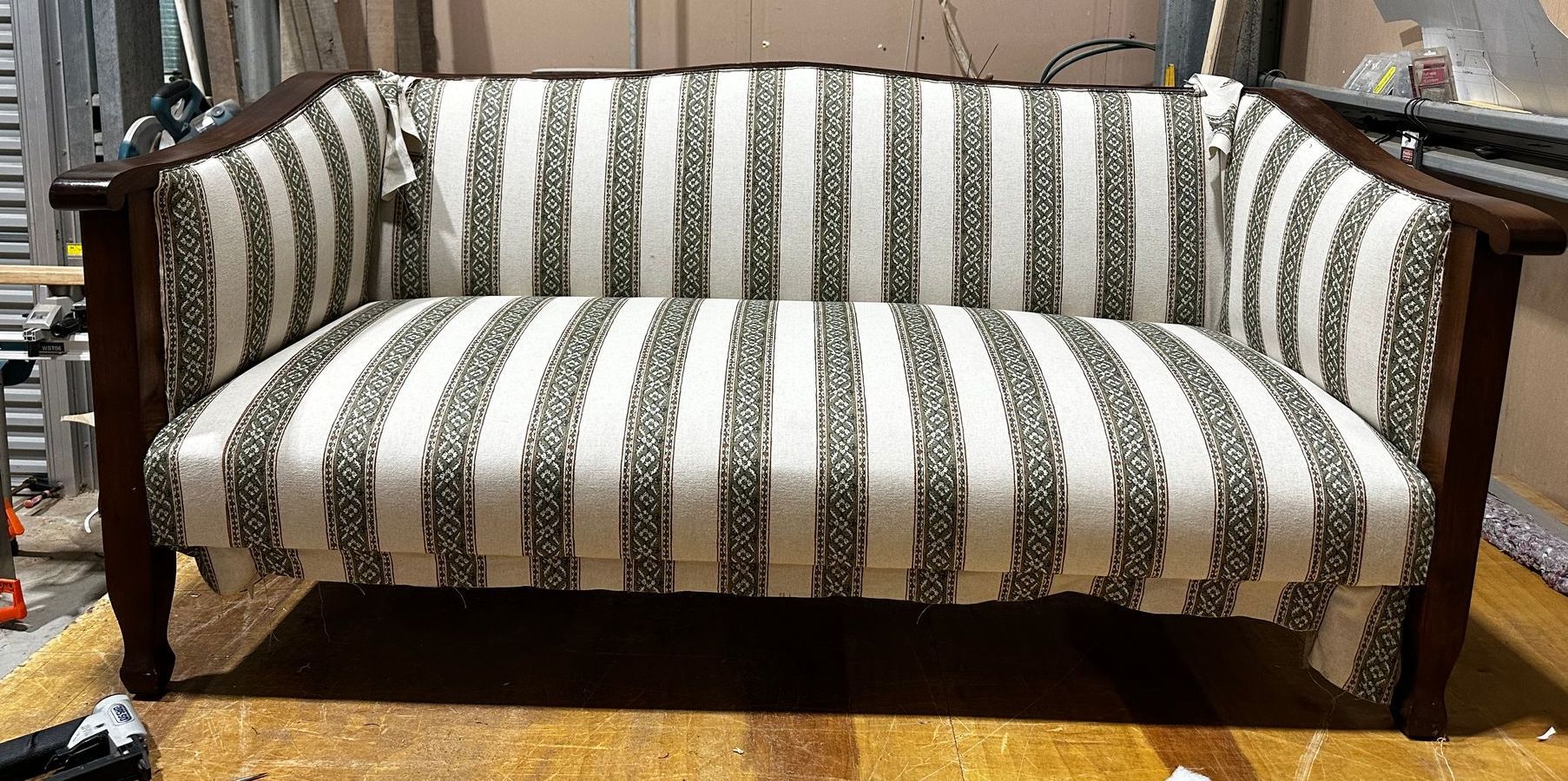 A Striped Couch On A Wooden Floor — Paulie's Upholstery in Edmonton, QLD