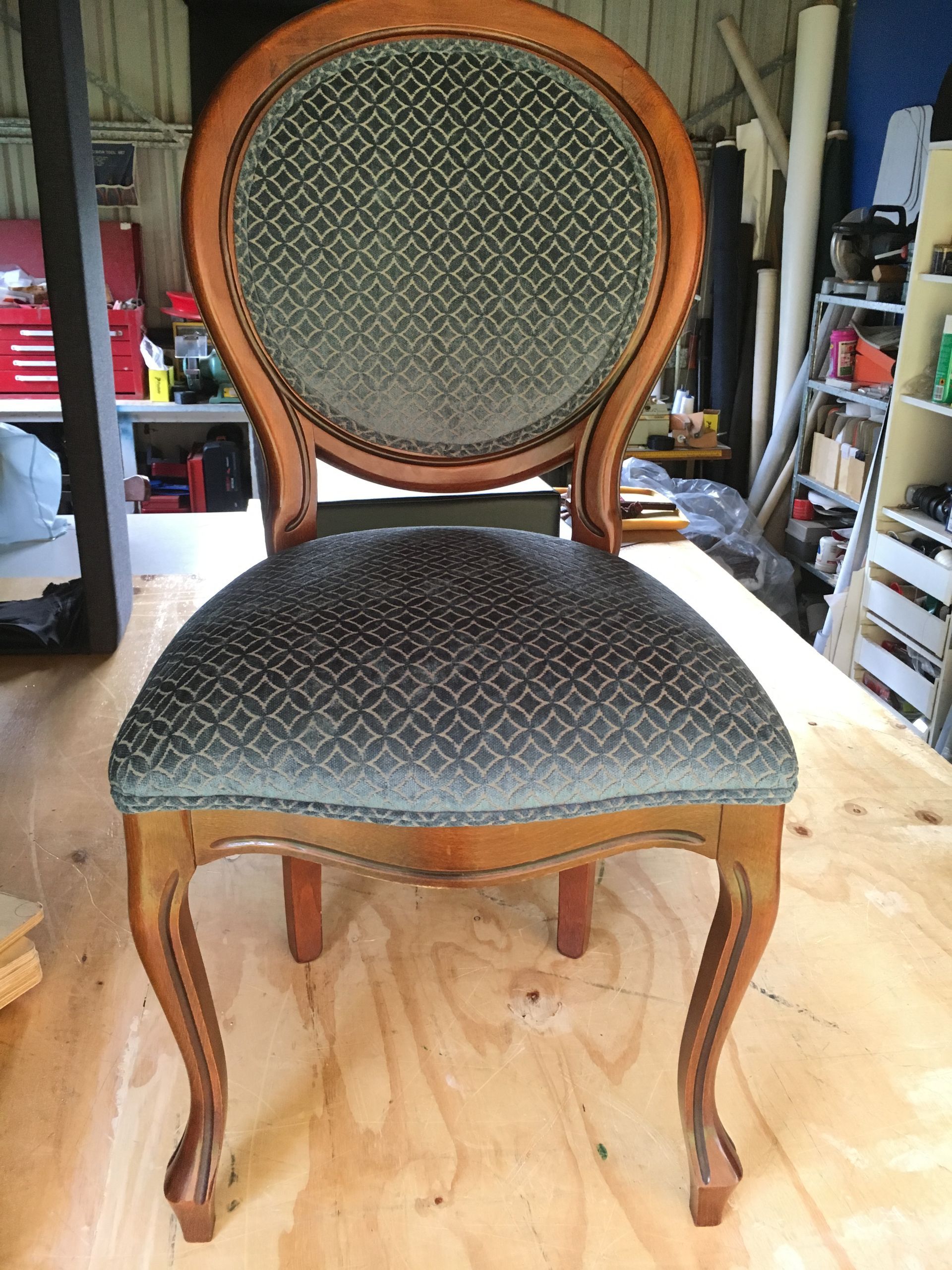 A Wooden Chair With a Grey Cushion is on a Wooden Table — Paulie's Upholstery in Edmonton, QLD