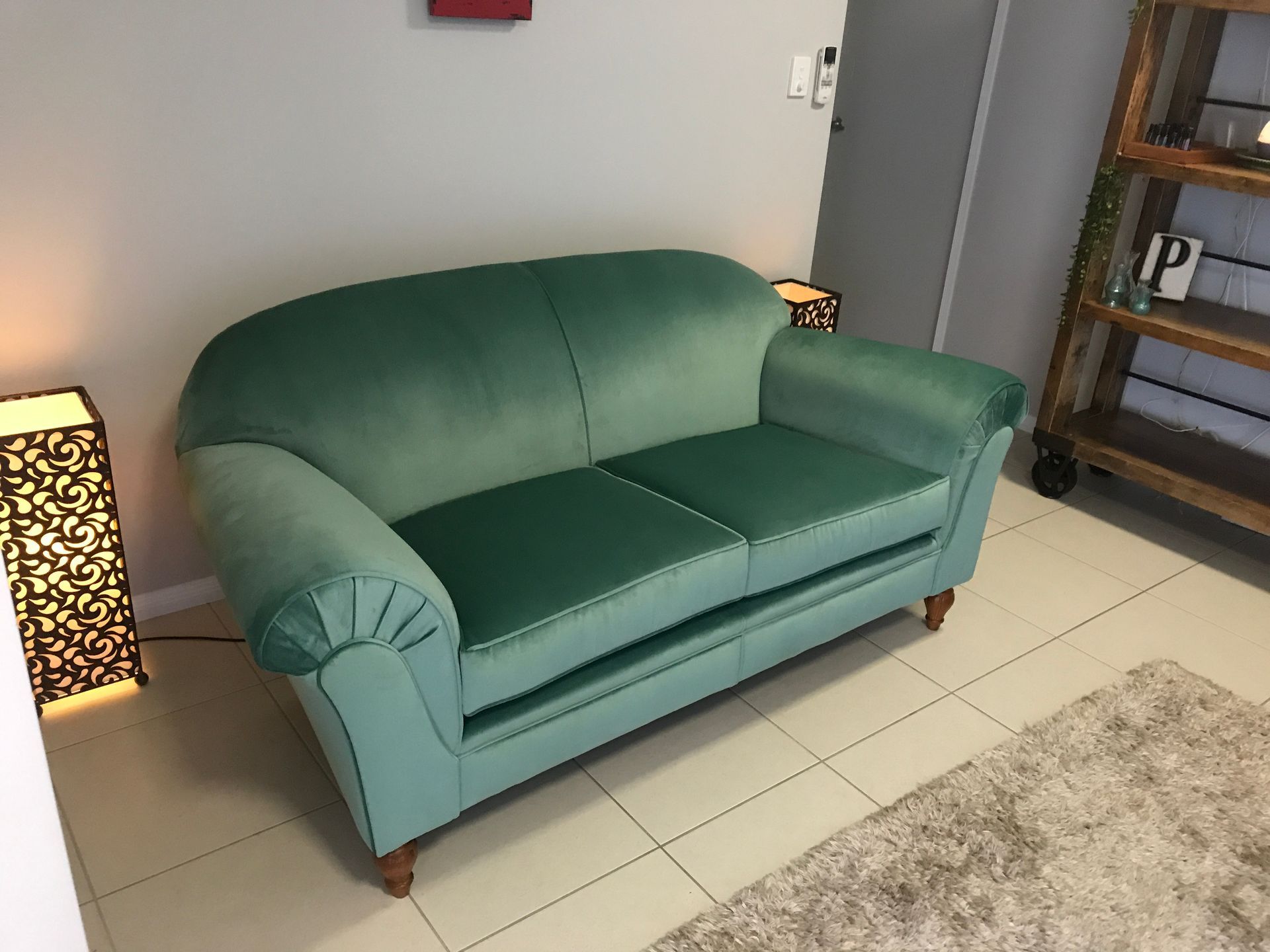 A Green Couch Is on a Tiled Floor in a Room — Paulie's Upholstery in Edmonton, QLD