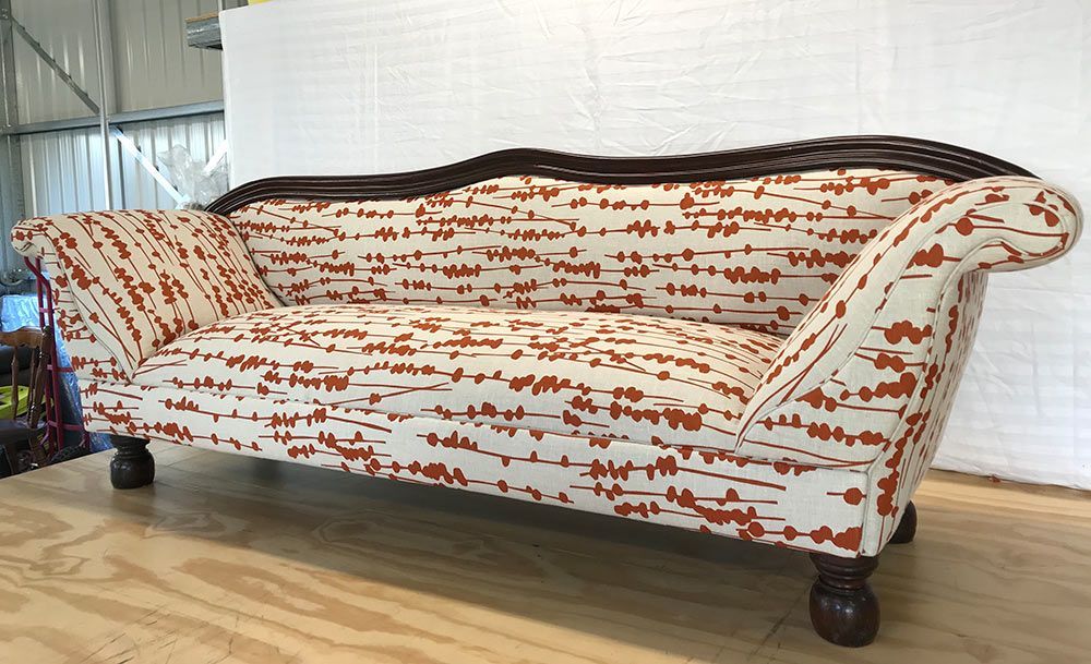A Red and White Couch is on a Wooden Floor — Paulie's Upholstery in Gordonvale, QLD