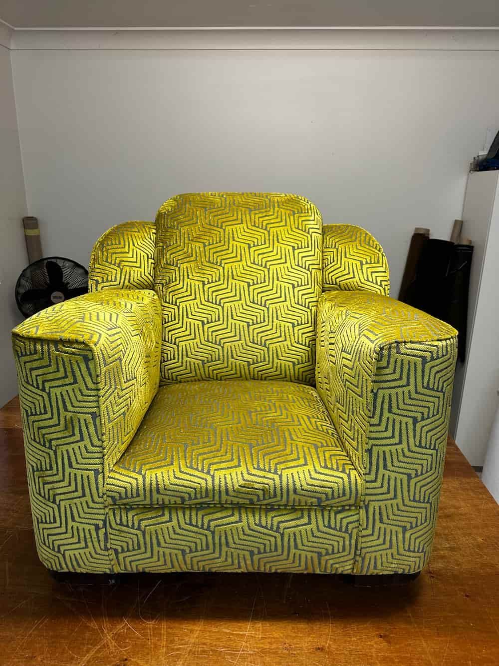 A Yellow Chair Is Sitting On A Wooden Floor In A Room — Paulie's Upholstery in Edmonton, QLD
