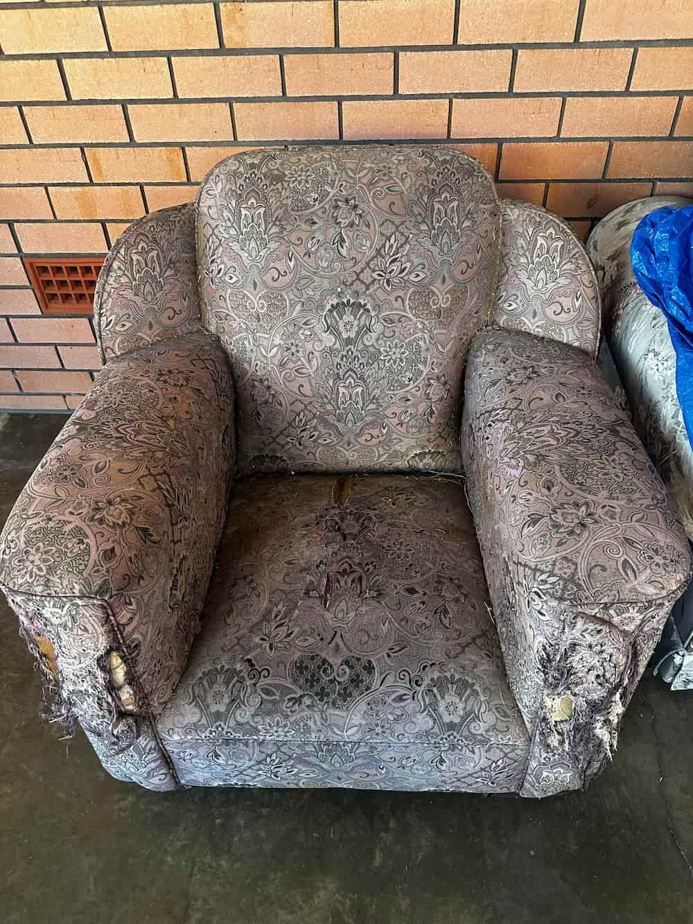 A Chair Is Sitting In Front Of A Brick Wall  — Paulie's Upholstery in Edmonton, QLD
