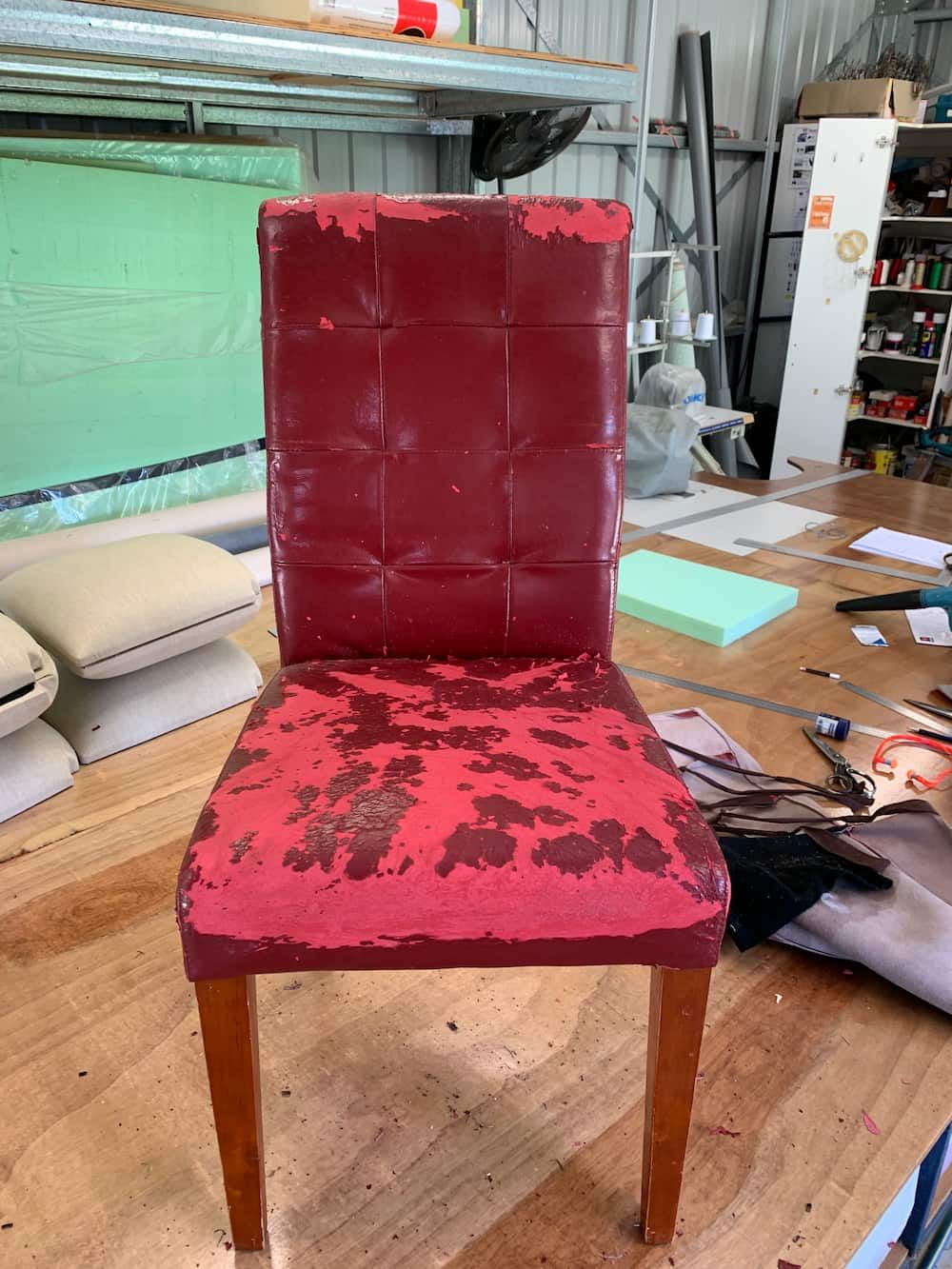 A Red Chair Is Sitting On A Wooden Floor In A Room — Paulie's Upholstery in Edmonton, QLD