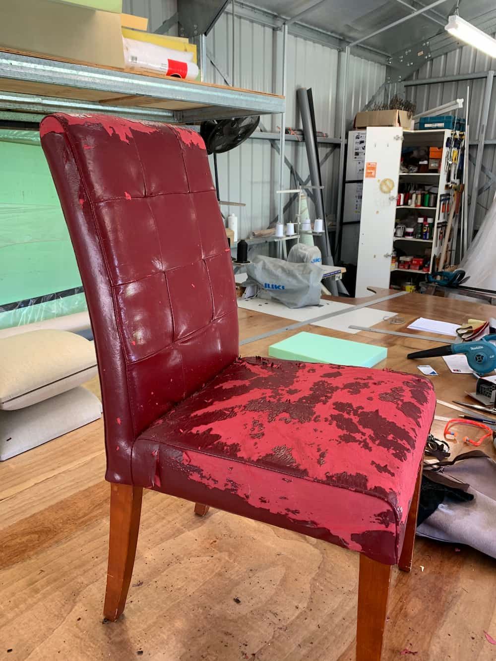 A Red Chair Is Sitting On A Wooden Floor In A Room  — Paulie's Upholstery in Edmonton, QLD
