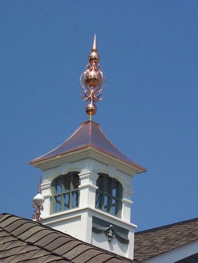 White cupola with copper weathervane a white cupola with a copper weather vane on top of it .