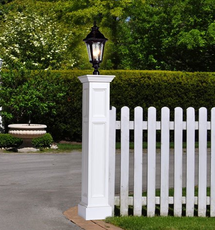 Front walkway to a house with colorful landscaping and a white lamp post near the entrance