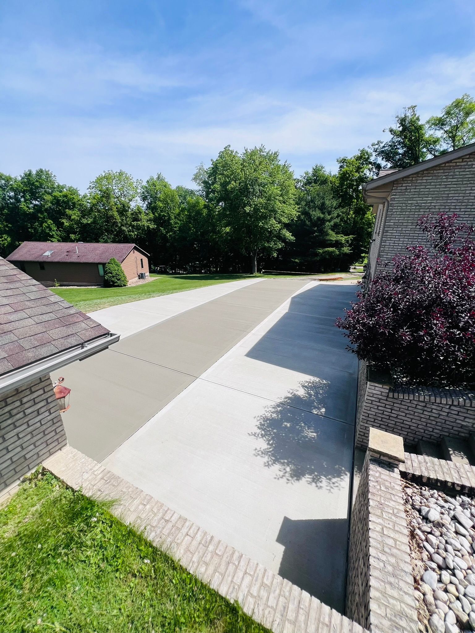 An aerial view of a driveway leading to a house surrounded by trees.