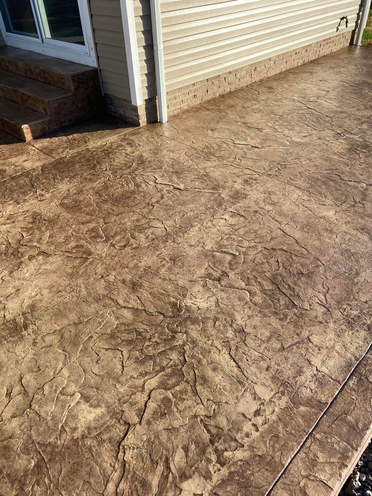 A close up of a concrete patio in front of a house.