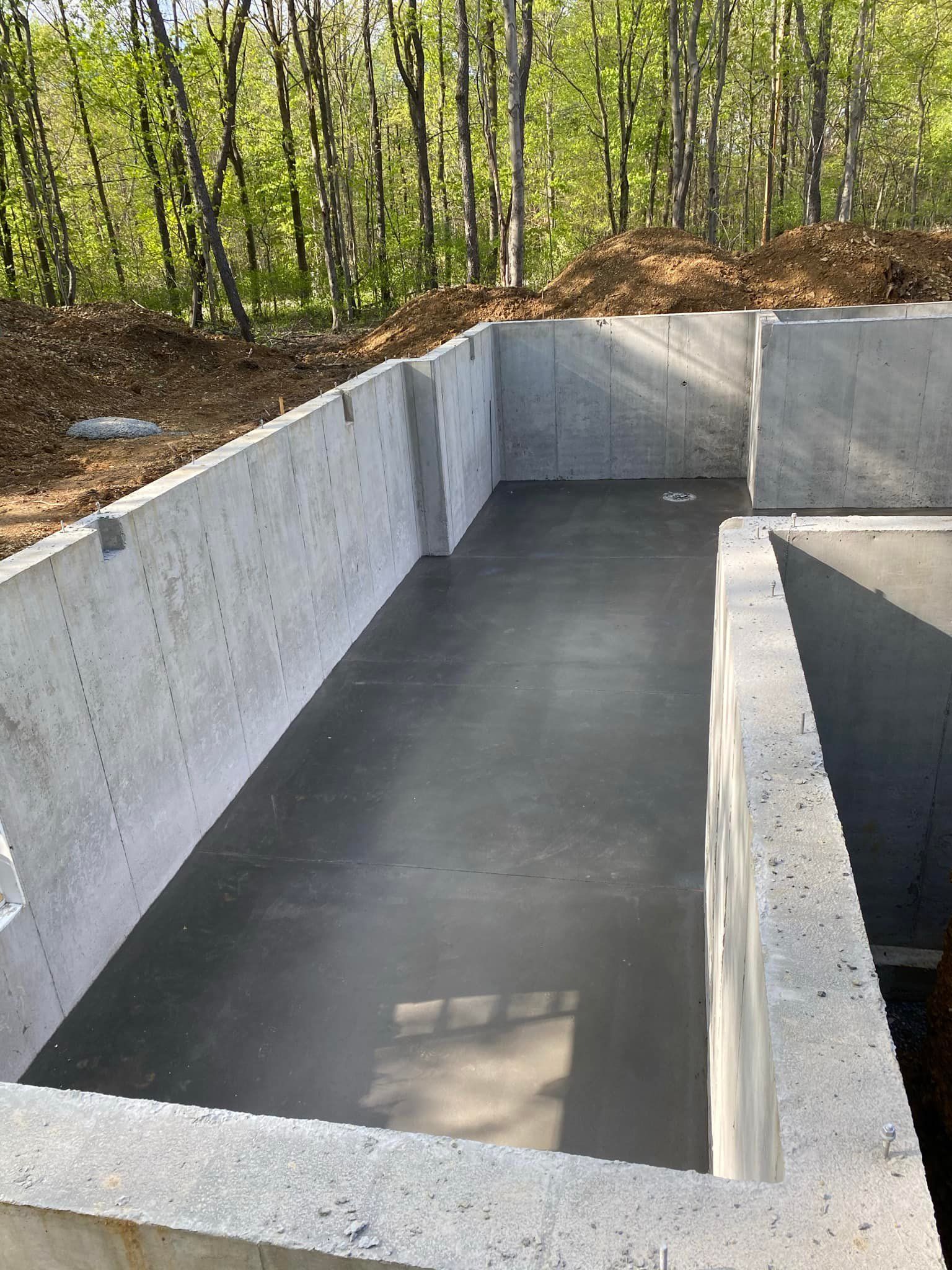 A large concrete foundation is being built in the woods.