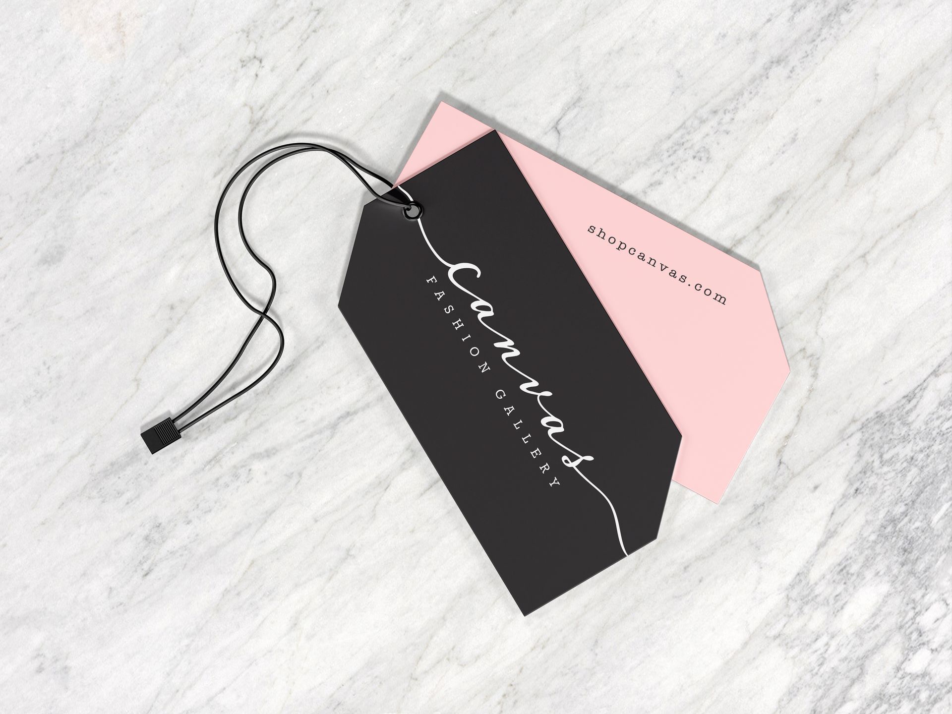 Black and pink gift tags with a black cord on a light marble surface