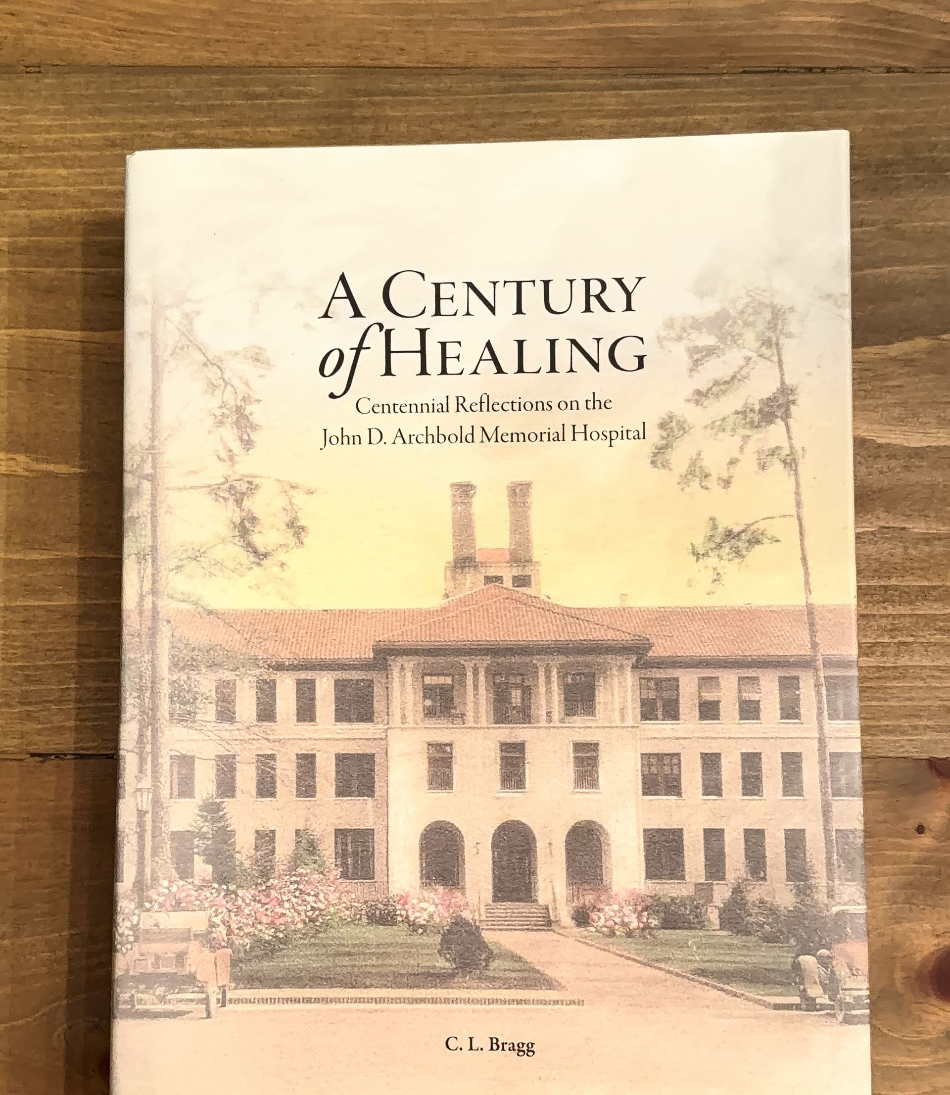Book cover of A Century of Healing, showing a historic building in warm sepia tones.