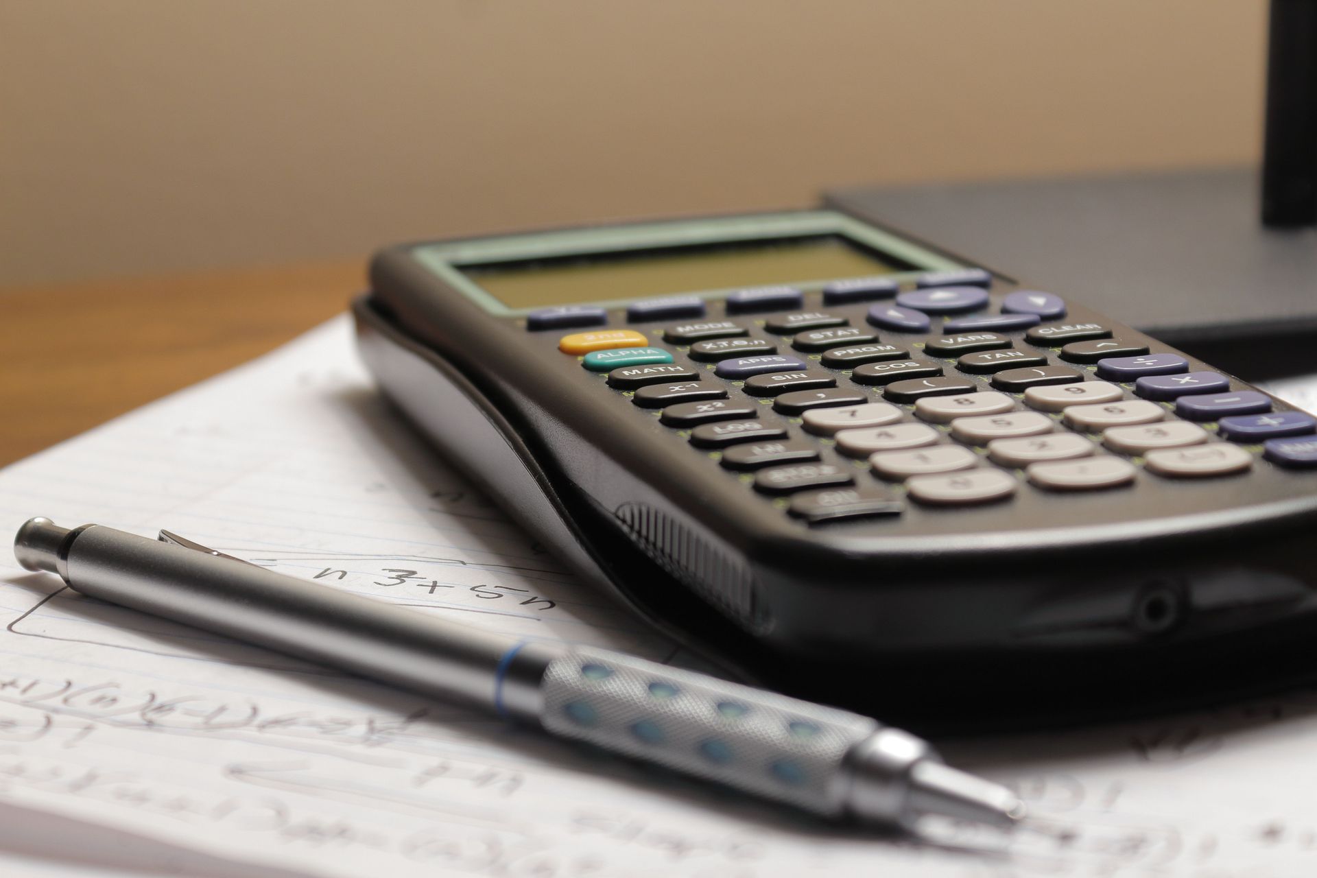 Calculator and pen on paperwork on a desk