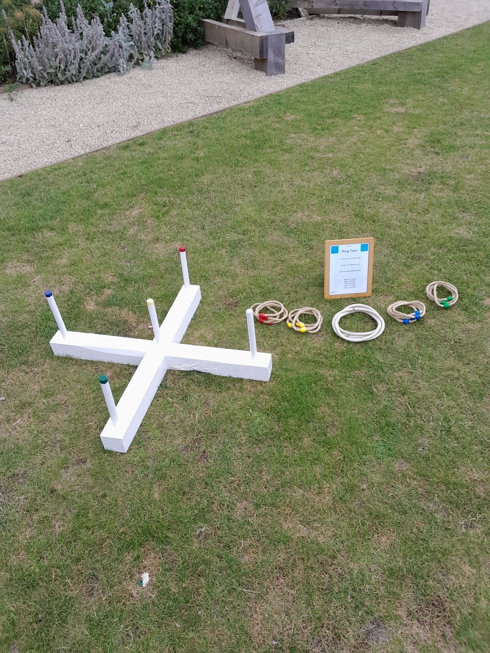 Wooden white lawn game ring toss on grass.