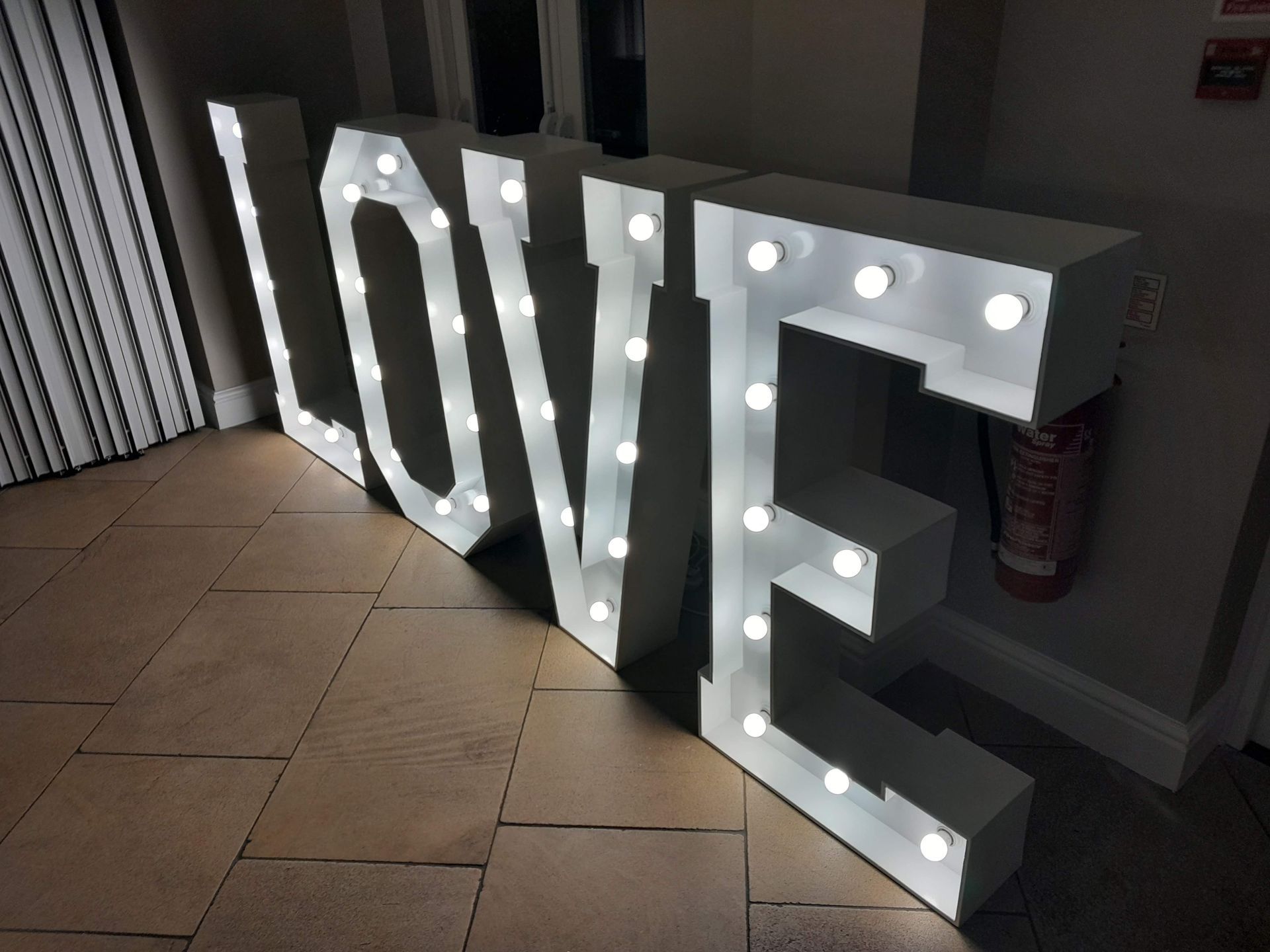 White light up letters L,O,V,E set up for a wedding with a disco.