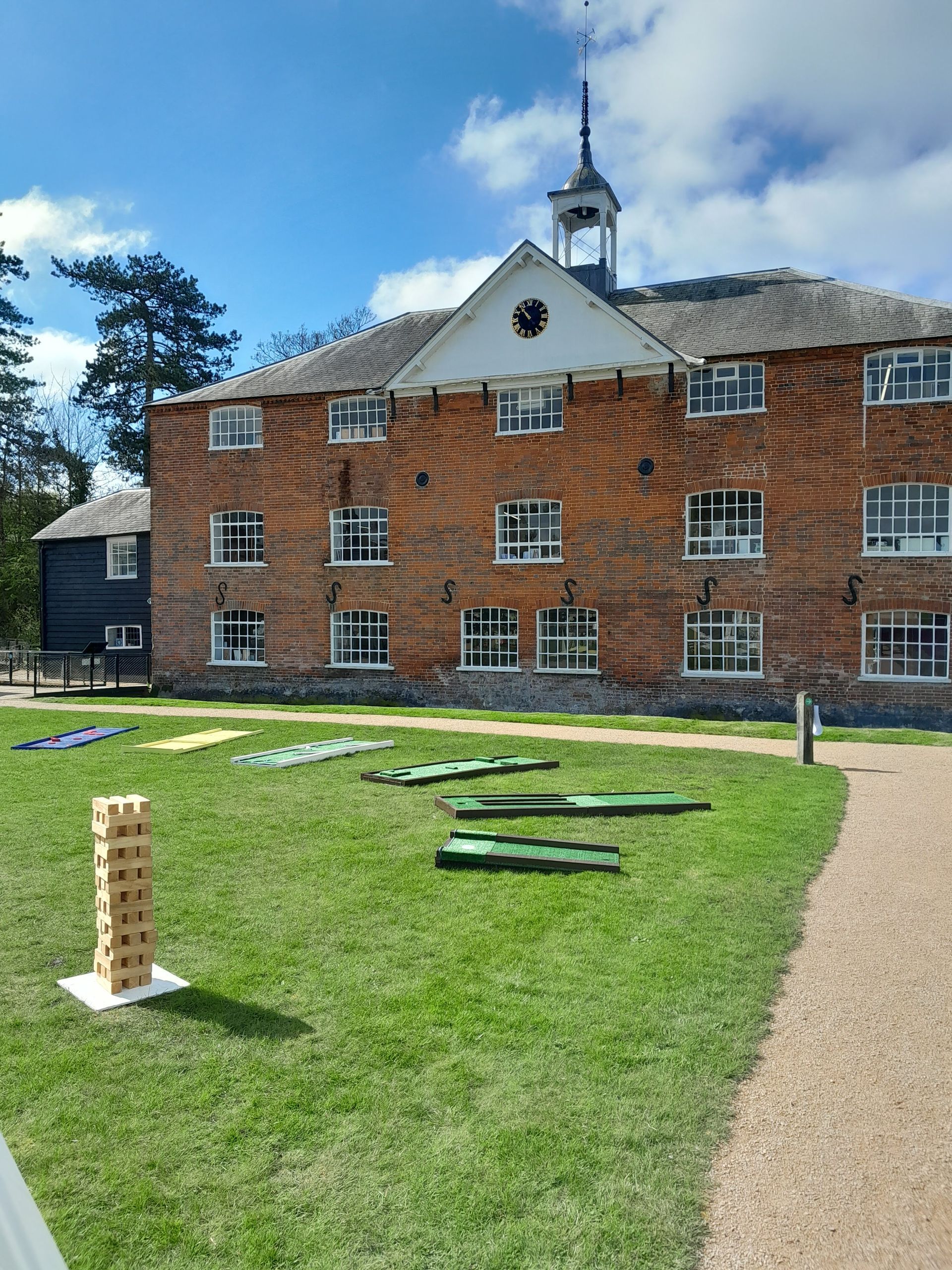 Min golf course set up on grass with other lawn games at Whitchurch Mill.