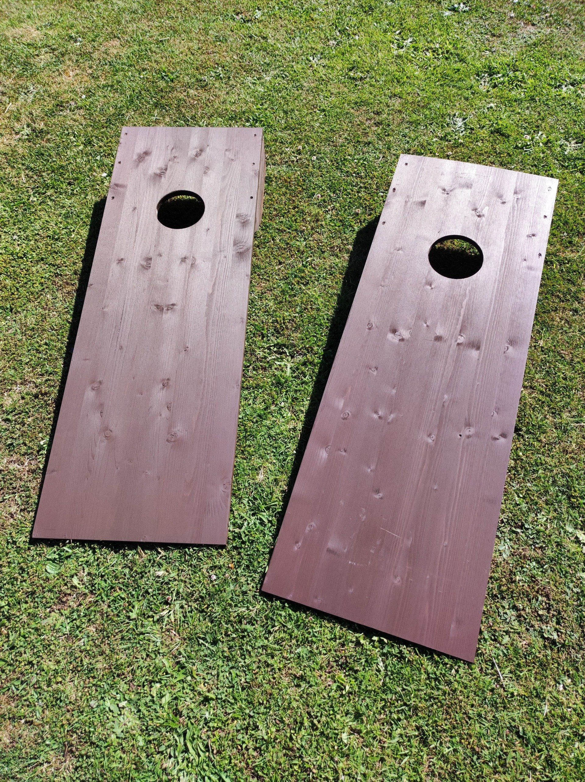 2 Wooden Cornhole lawn game on grass at a hotel.