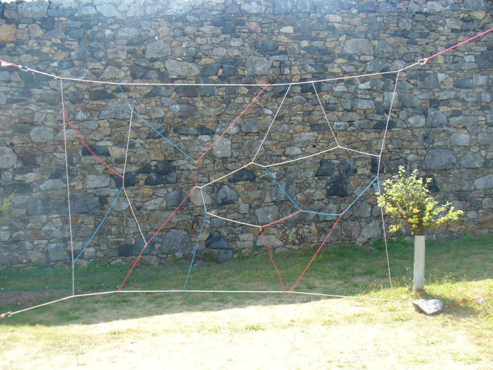 A spider web team building game made of rope and wood.