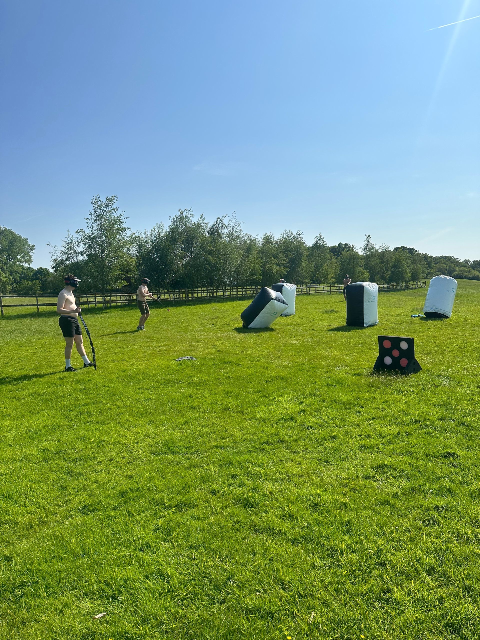 A stag group playing archery tag on a field.