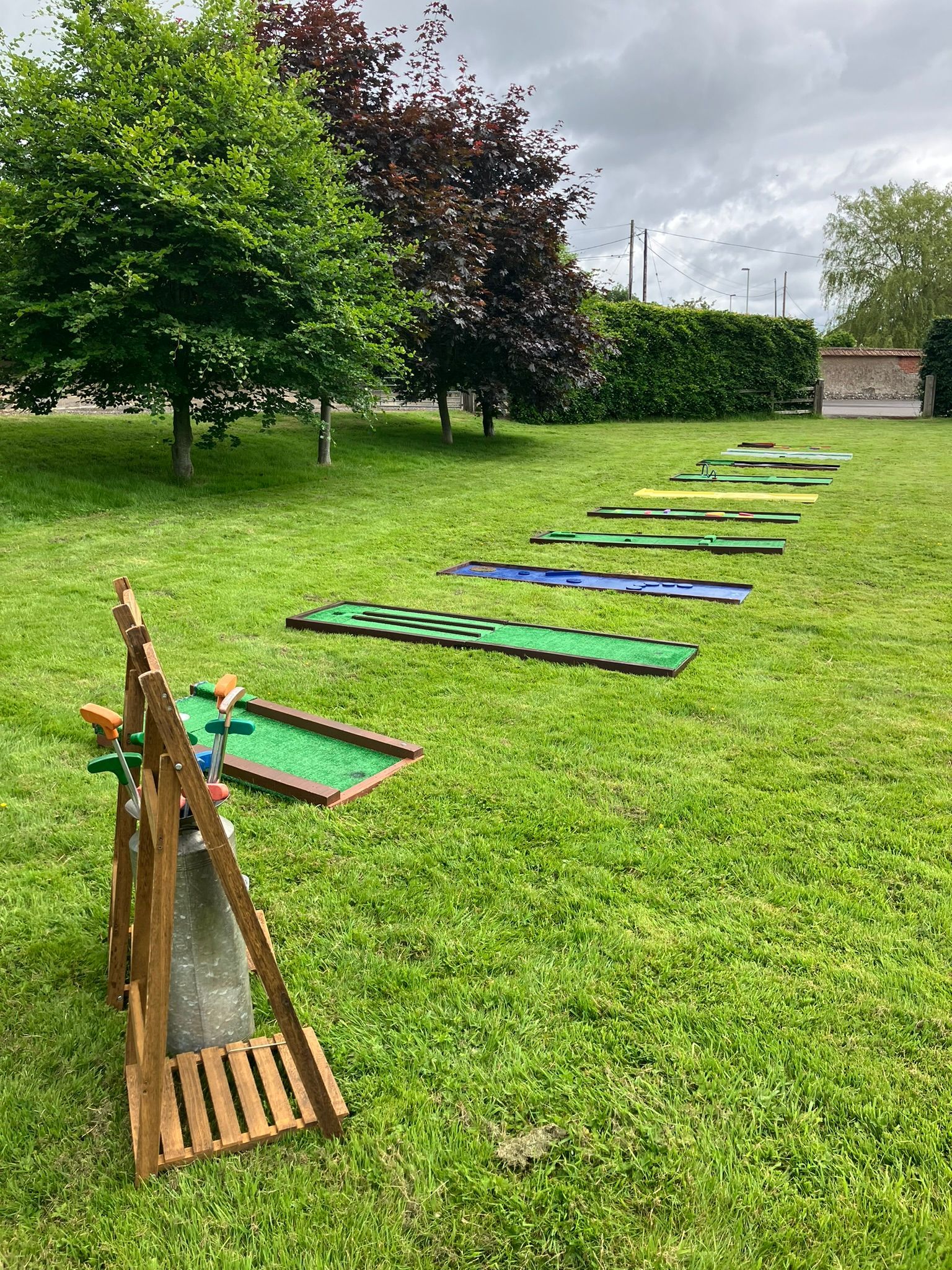 Mini golf set up on a field for a wedding.  Lined up next to each other.