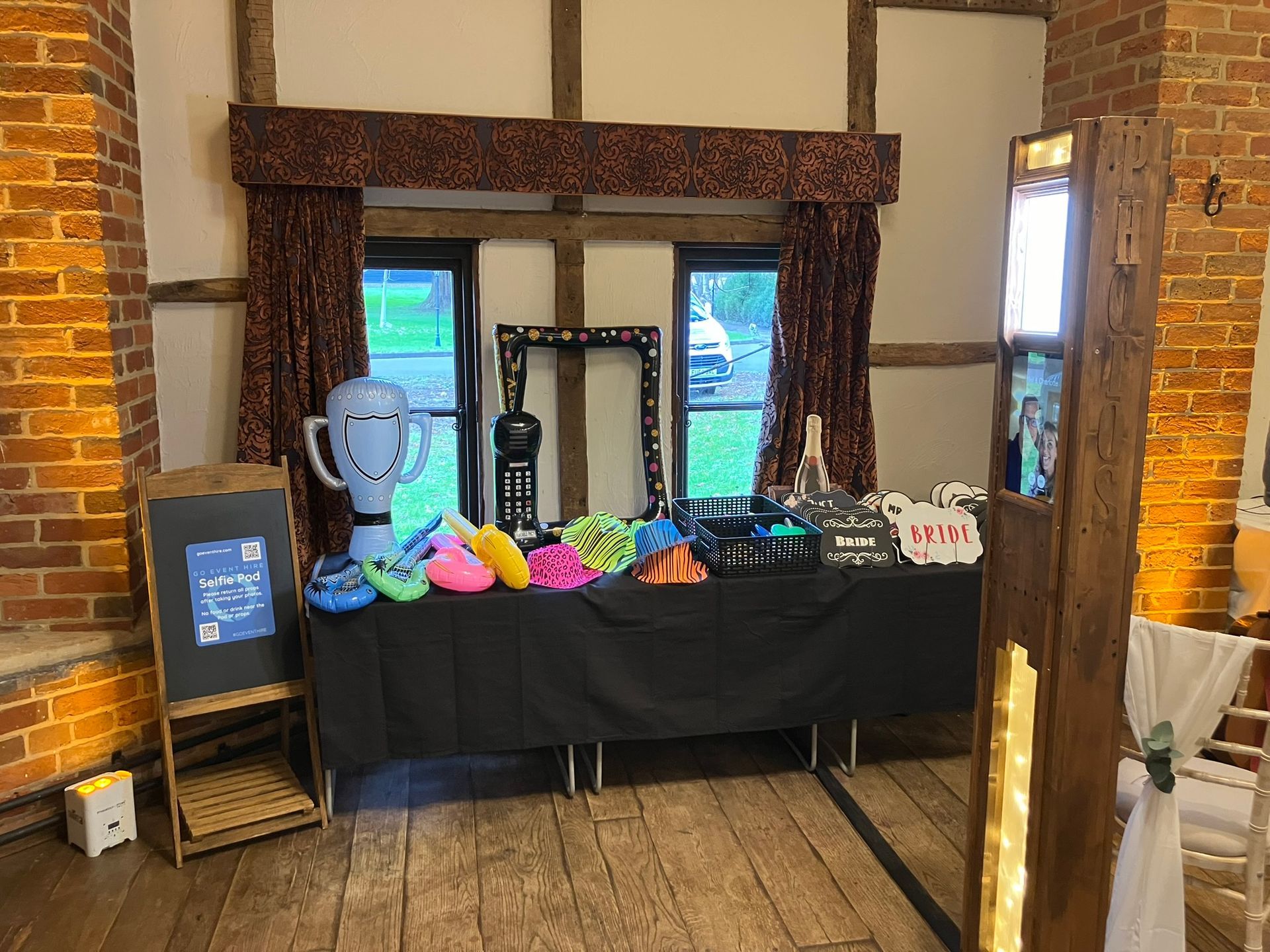 Wooden selfie pod next to props on a table.