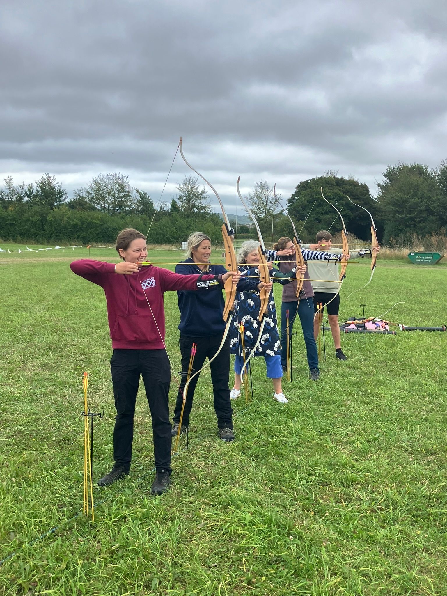 Archery hire in Hampshire, people holding bows and others watching