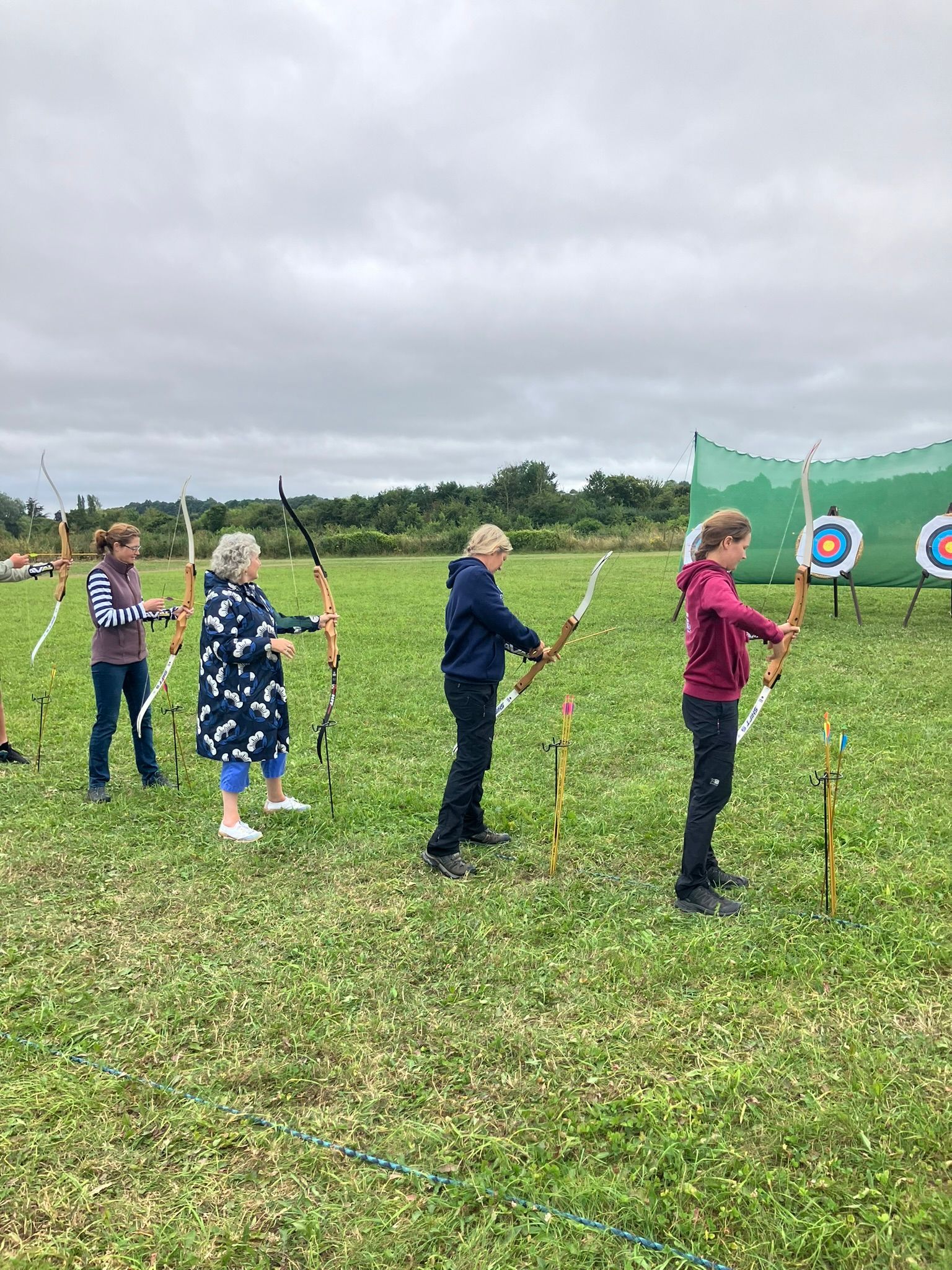 Archery hire in Hampshire, people holding bows and others watching