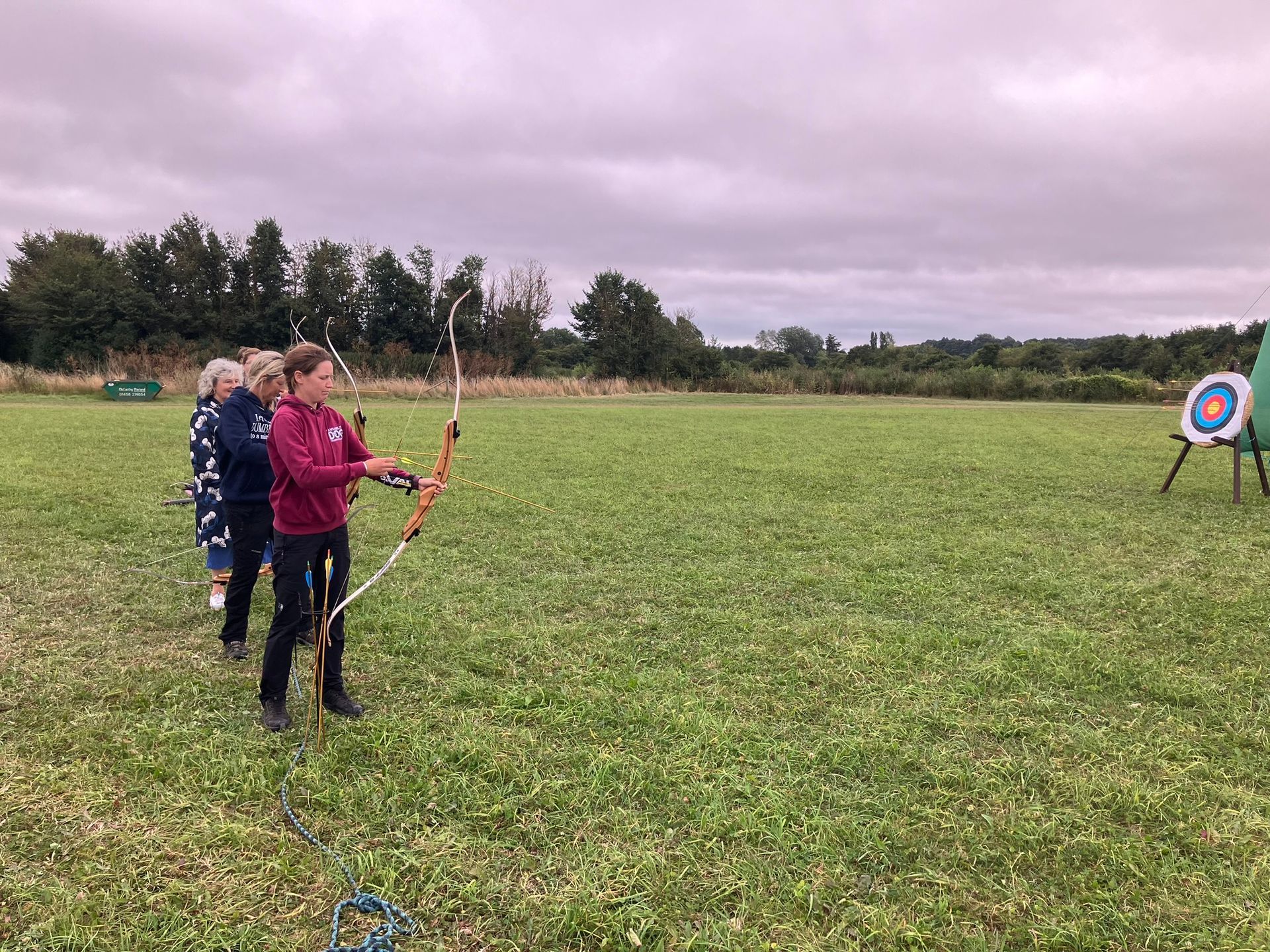 Archery hire in Hampshire, people holding bows and others watching