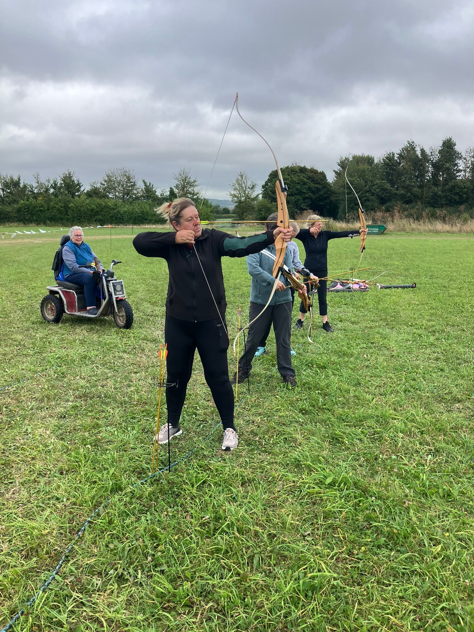 Archery hire in Hampshire, people holding bows and others watching