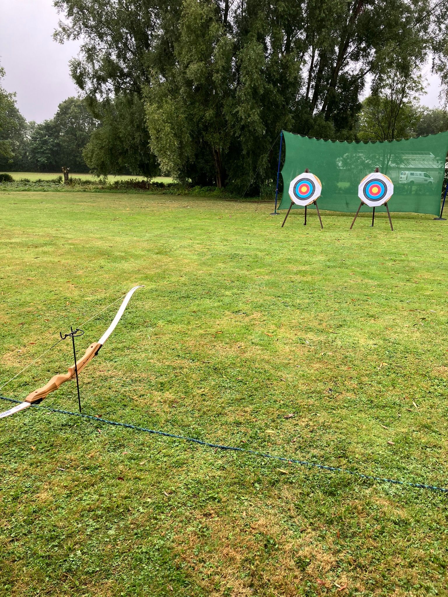 2 archery target on a field with bows set up 