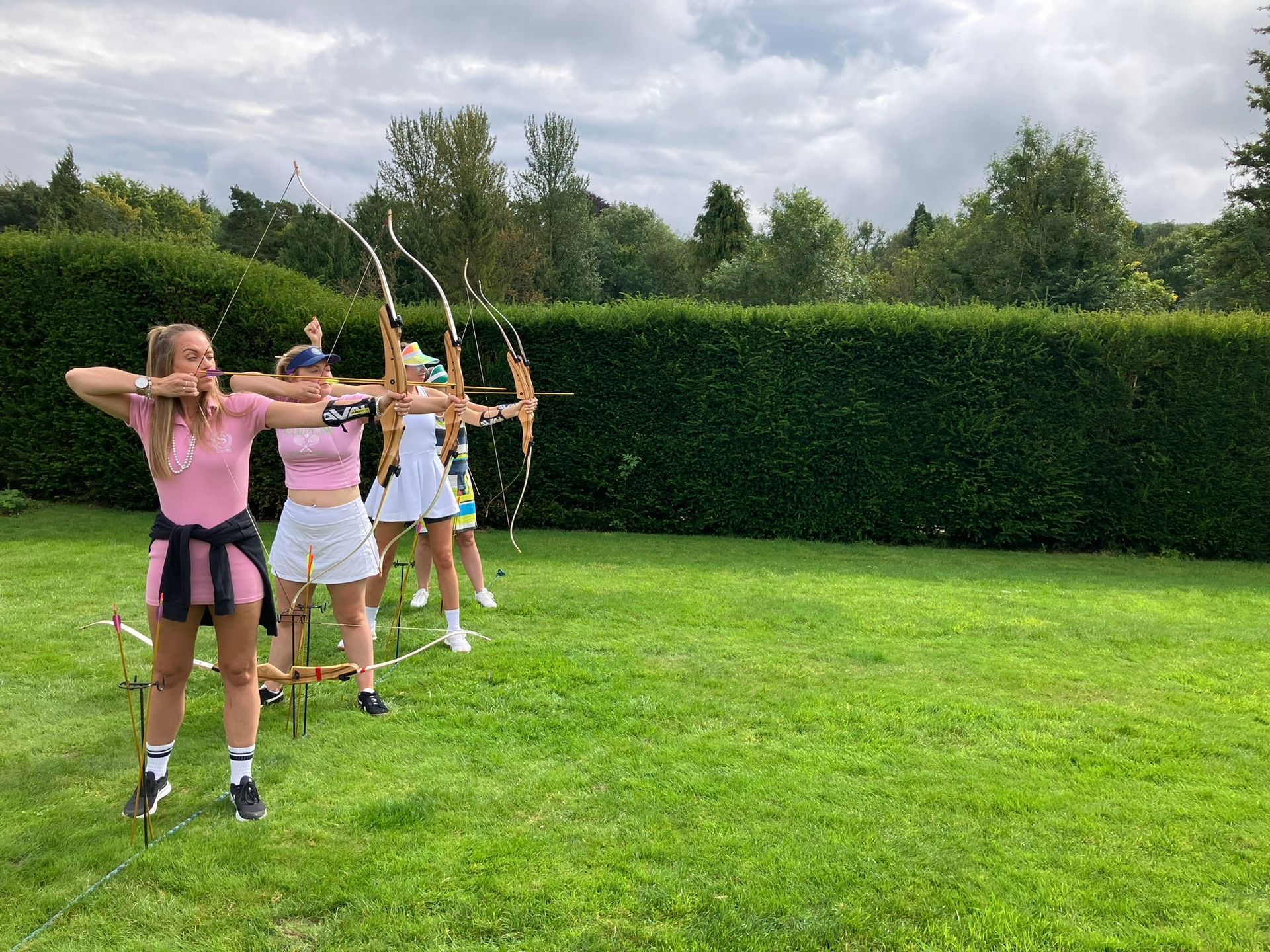Archery hire in Hampshire, people holding bows and others watching