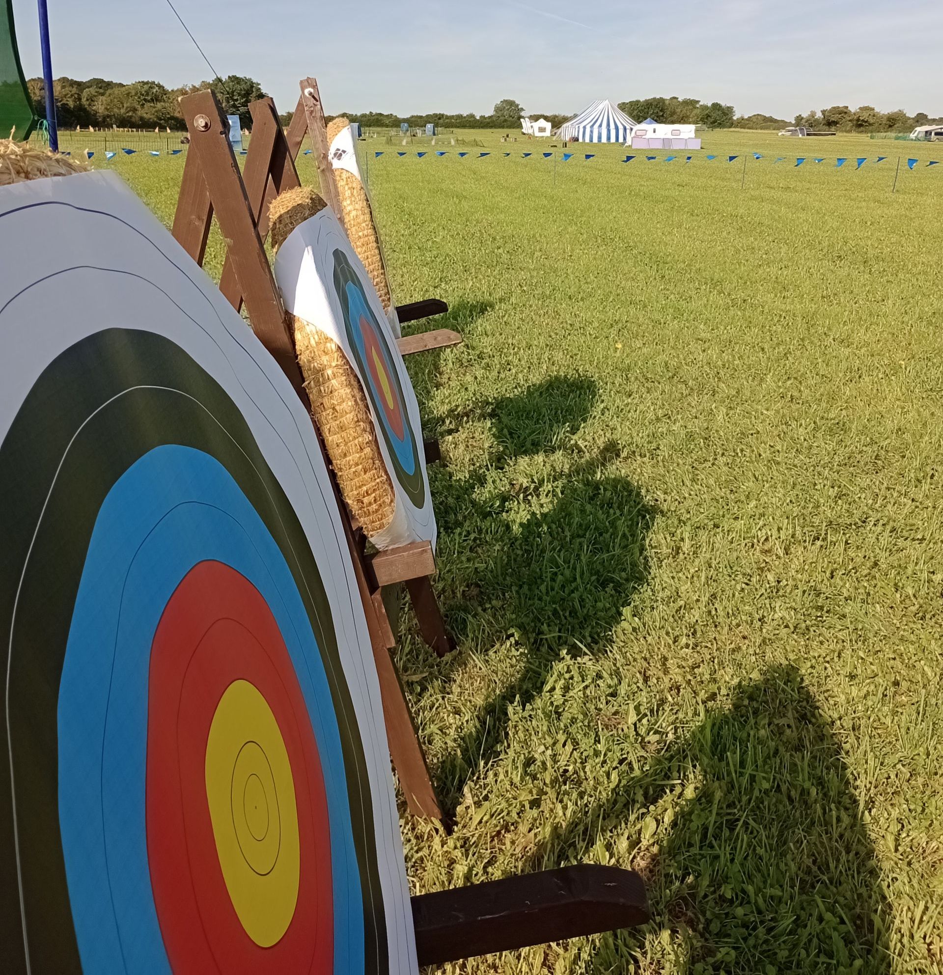 3 archery targets in a line on a field
