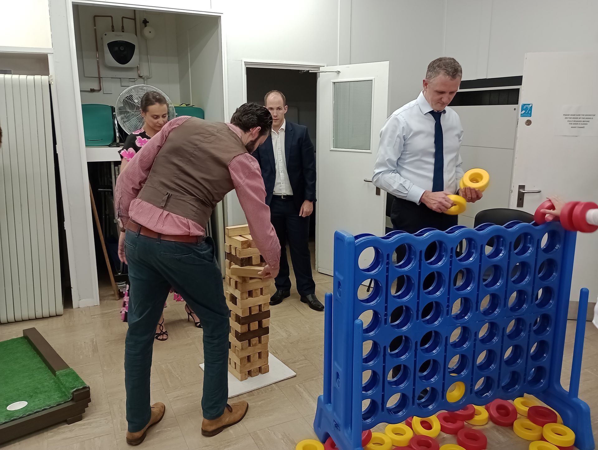Adult wedding guests playing a competitive game of giant connect 4.