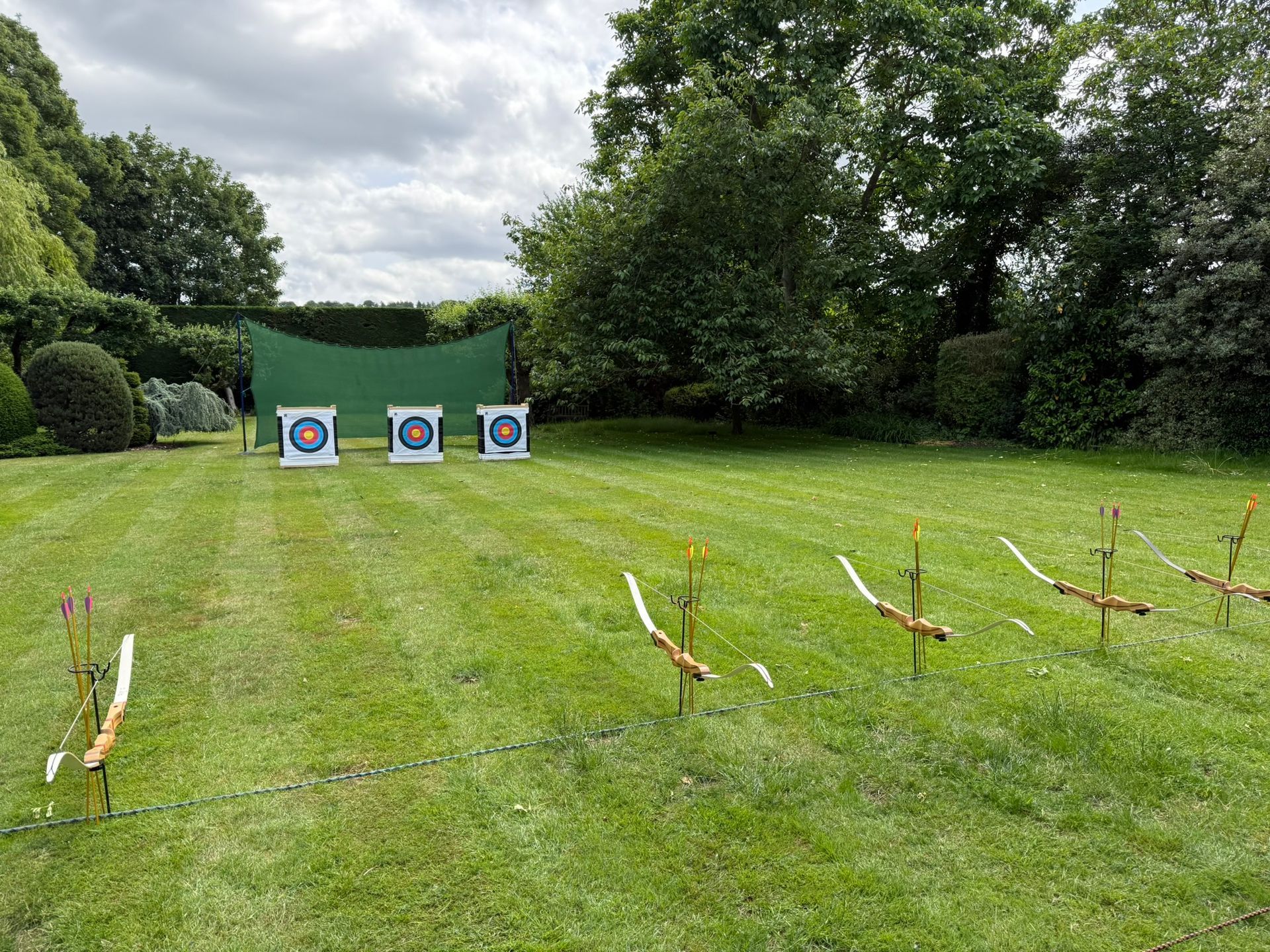 3 archery target on a field with bows set up 