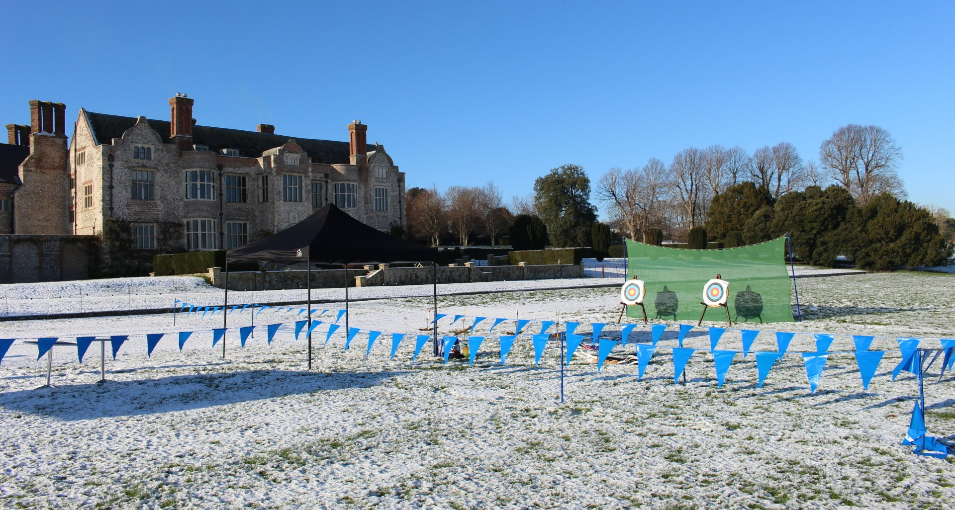 Corporate event in Glynde Place for a Christmas celebration.  Archery and axe throwing on a snowy field.