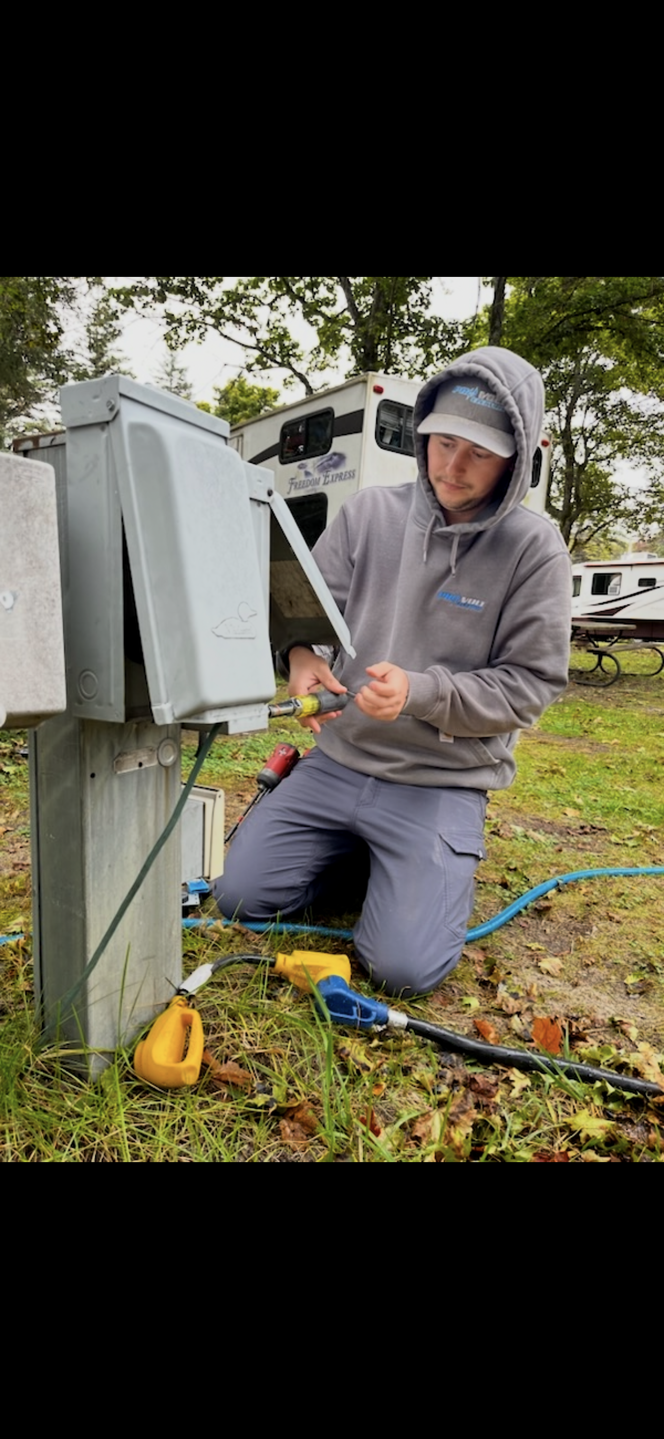 Electrician testing a residential wall outlet with a digital voltage meter.