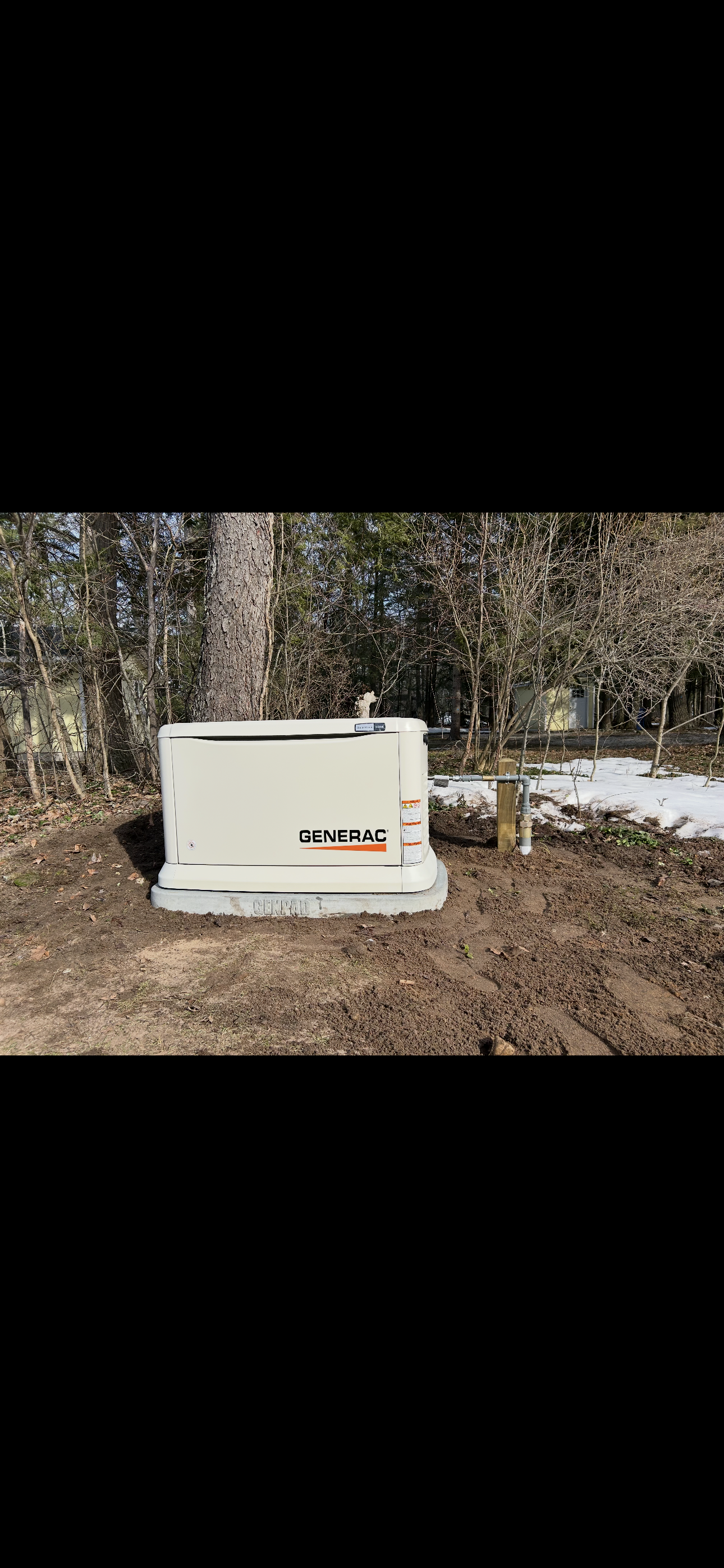 Automatic transfer switch enclosure mounted beside an electrical panel.