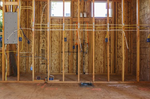Electrician wiring a new construction home during rough-in