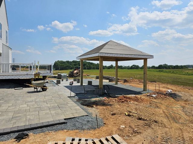 Small pavilion beside a paved patio at a construction site under a bright blue sky
