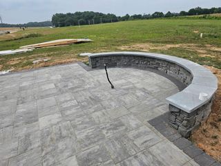Curved stone seating around a sunken patio in a grassy outdoor field