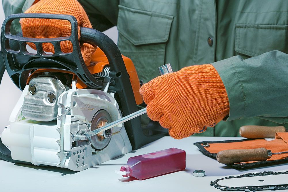 A Person is Using a Chainsaw to Sharpen a Chain — Ken Mills Machinery in Kingaroy, QLD
