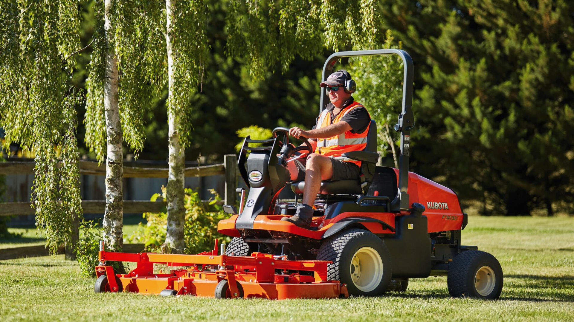 A red lawn mower is cutting a lush green lawn. — Ken Mills Machinery in Kingaroy, QLD