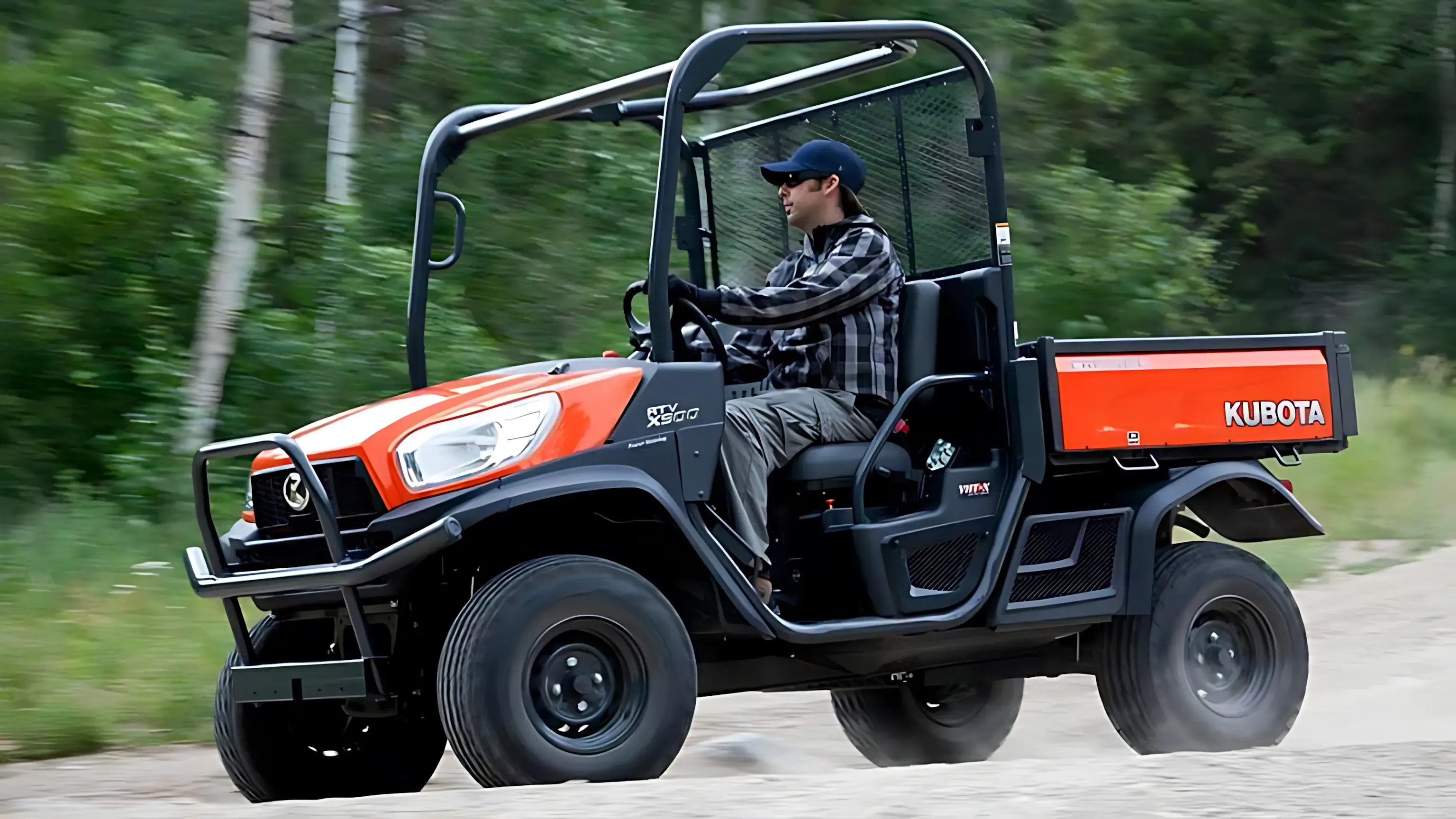 A man is driving a kubota utility vehicle on a dirt road. — Ken Mills Machinery in Kingaroy, QLD
