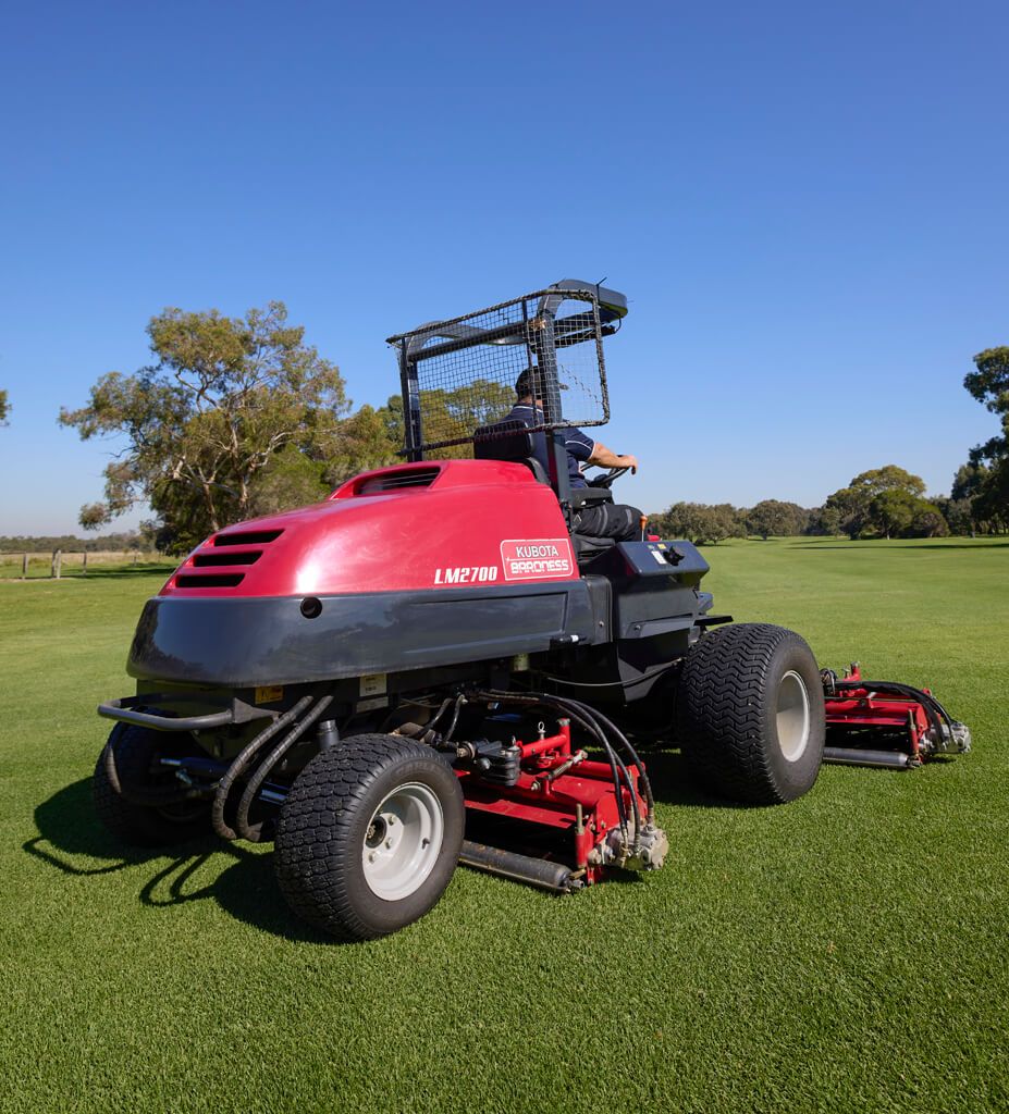 Red Riding Lawn Mower Mowing a Green Field Under a Blue Sky — Ken Mills Machinery in Eidsvold, QLD